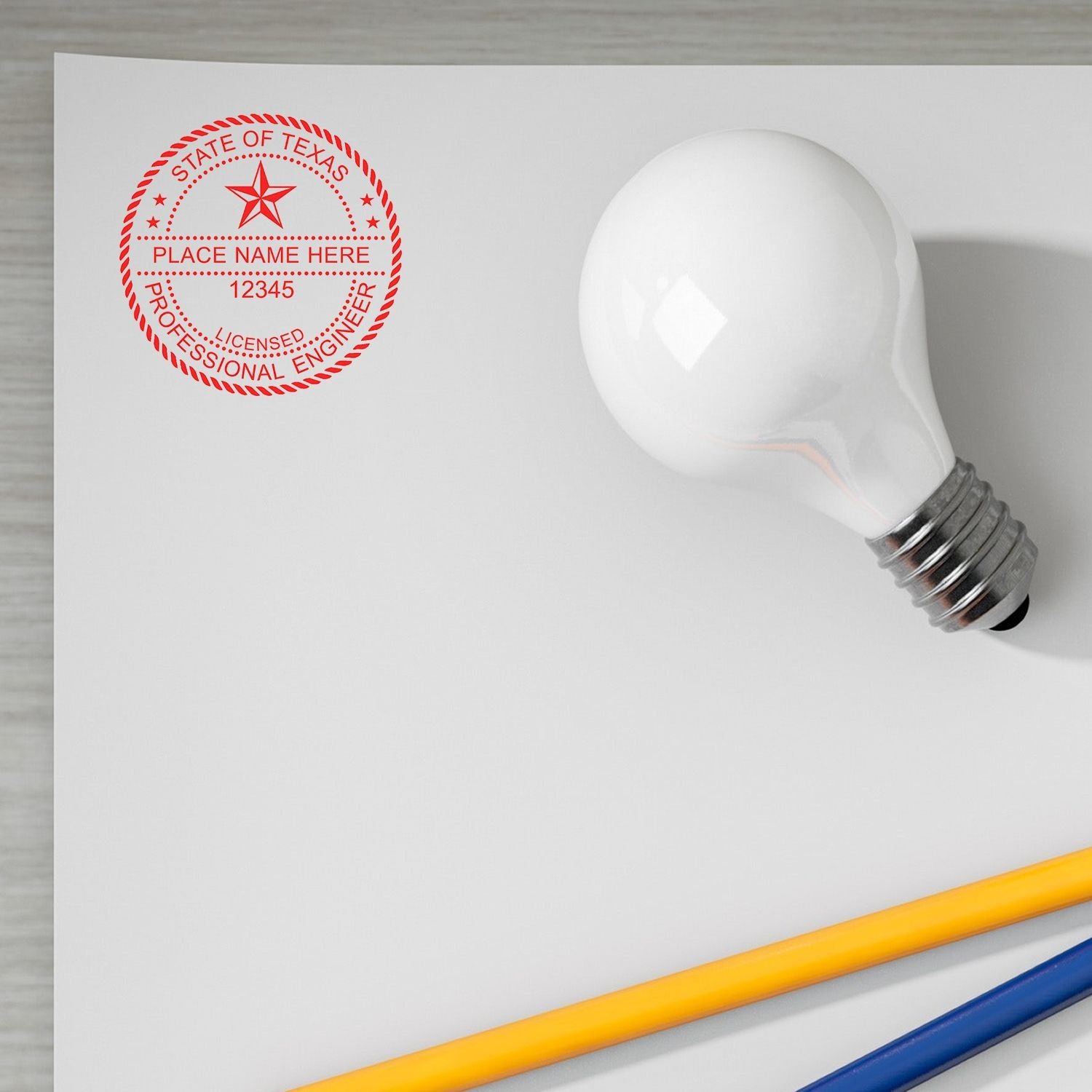 MaxLight Pre-Inked Professional Engineer Stamp of Seal in use on a white sheet of paper, next to a light bulb and two pencils. The stamp displays State of Texas and Licensed Professional Engineer.