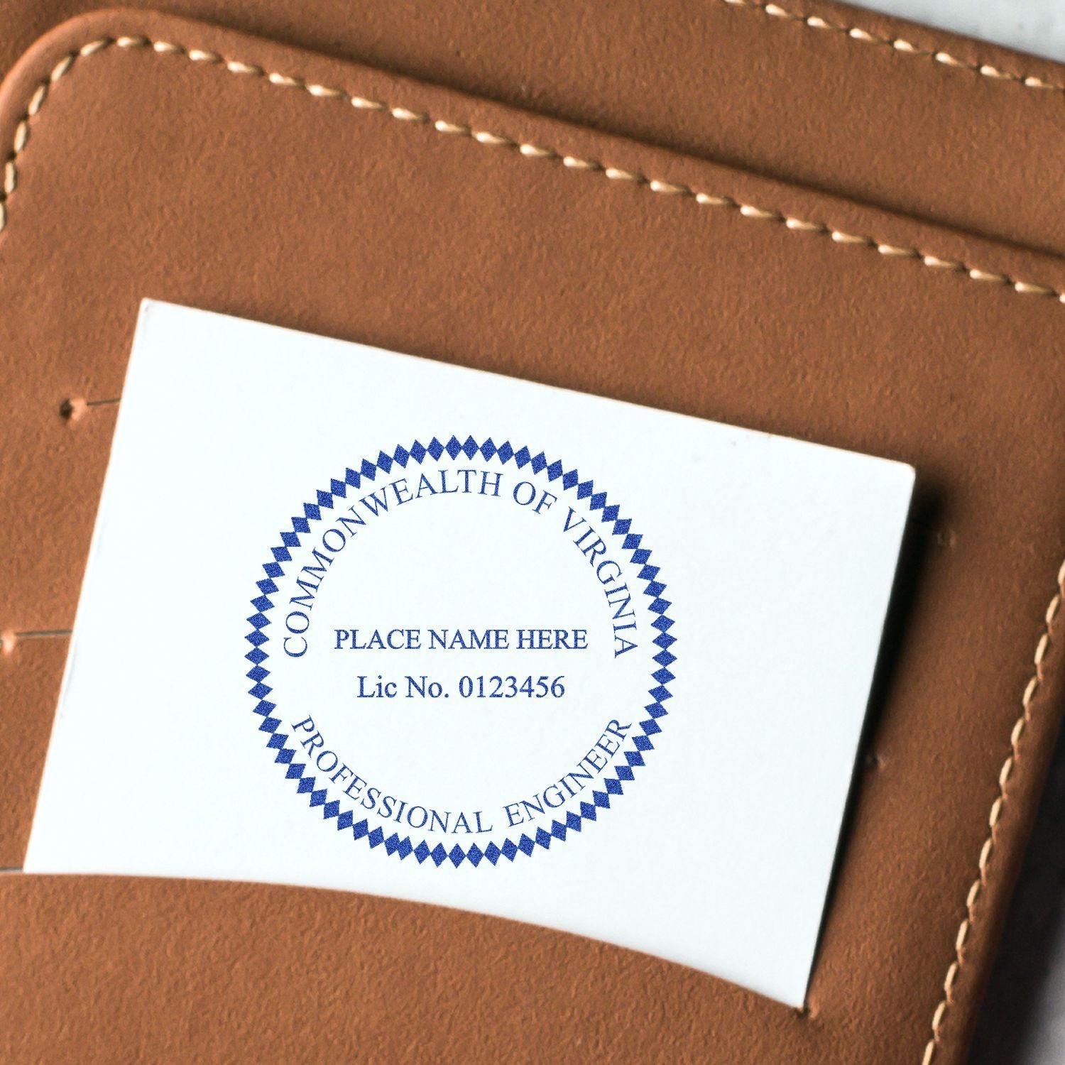 A close-up of a Professional Engineer Regular Rubber Stamp of Seal imprint on a white card, placed inside a brown leather wallet. The stamp reads Commonwealth of Virginia, Professional Engineer.