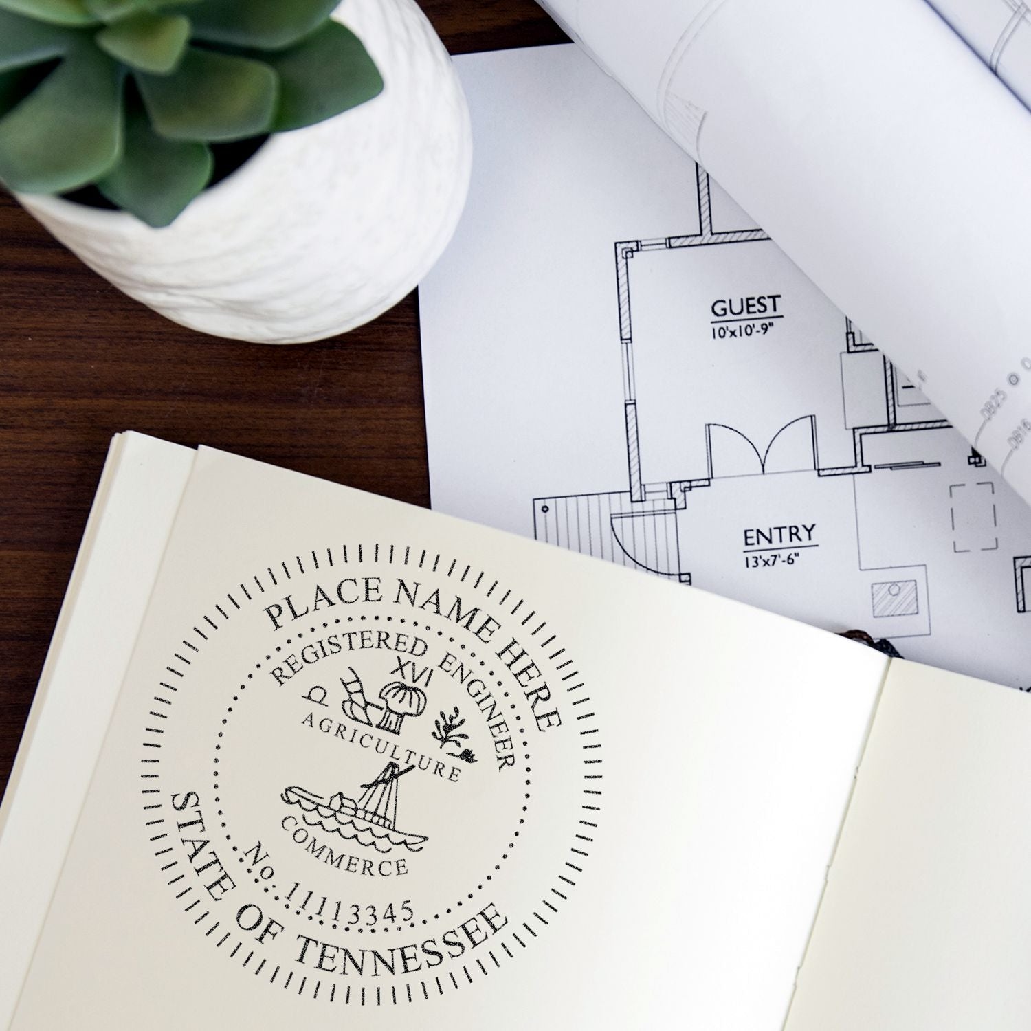 Professional Engineer Regular Rubber Stamp of Seal in use on a document, with architectural plans and a plant in the background. The stamp displays Registered Engineer and State of Tennessee.