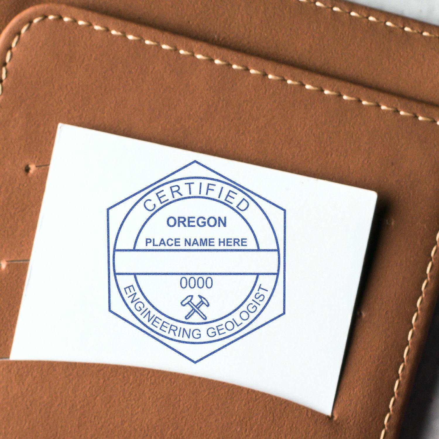 Engineering Geologist MaxLight Pre-Inked Rubber Stamp of Seal in use, displaying a certified Oregon engineering geologist seal on a white card placed in a brown leather wallet.