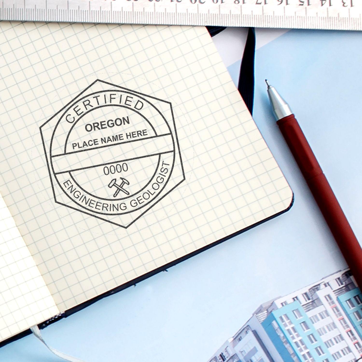 Engineering Geologist MaxLight Pre-Inked Rubber Stamp of Seal in use on a notebook, displaying a certified seal with Oregon and Engineering Geologist text, alongside a pen and ruler.