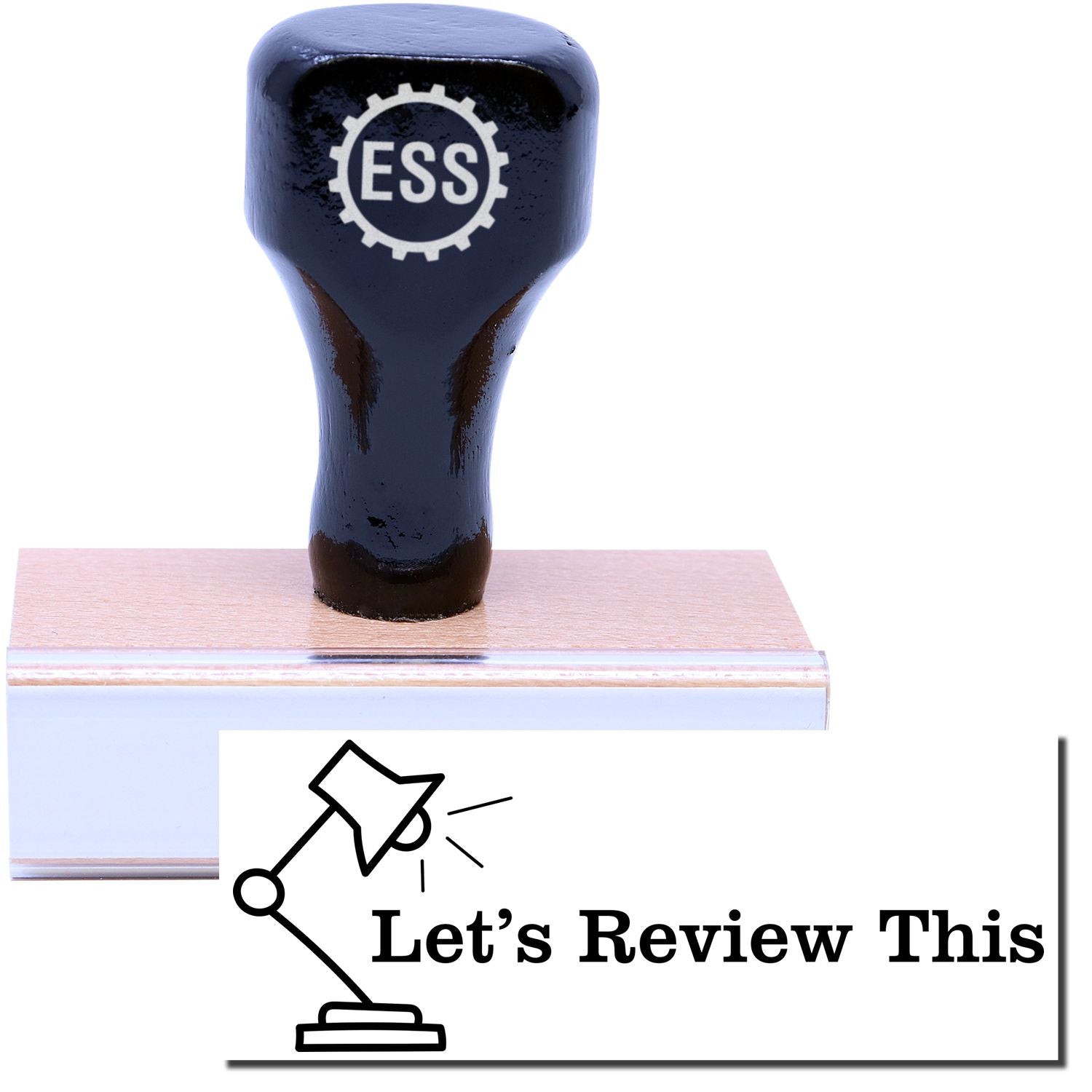 A stock office rubber stamp with a stamped image showing how the text "Let's Review This" with an image of a lamp on the left side is displayed after stamping.