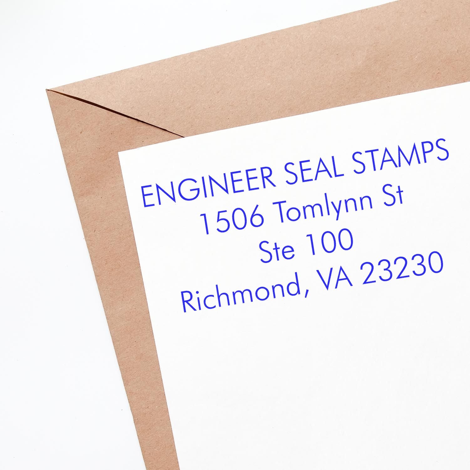 A brown envelope and a white paper stamped with blue ink using the 4 Line Self Inking Address Stamp, showing an address in Richmond, VA.