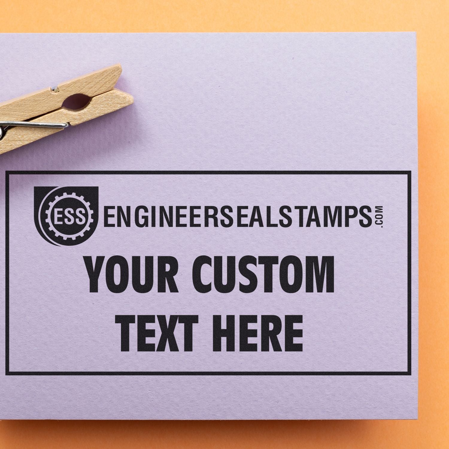 Custom Self Inking Stamp Trodat 4929 Size 1-3/16 x 2 used on a white card with YOUR CUSTOM TEXT HERE printed, clipped with a wooden clothespin.