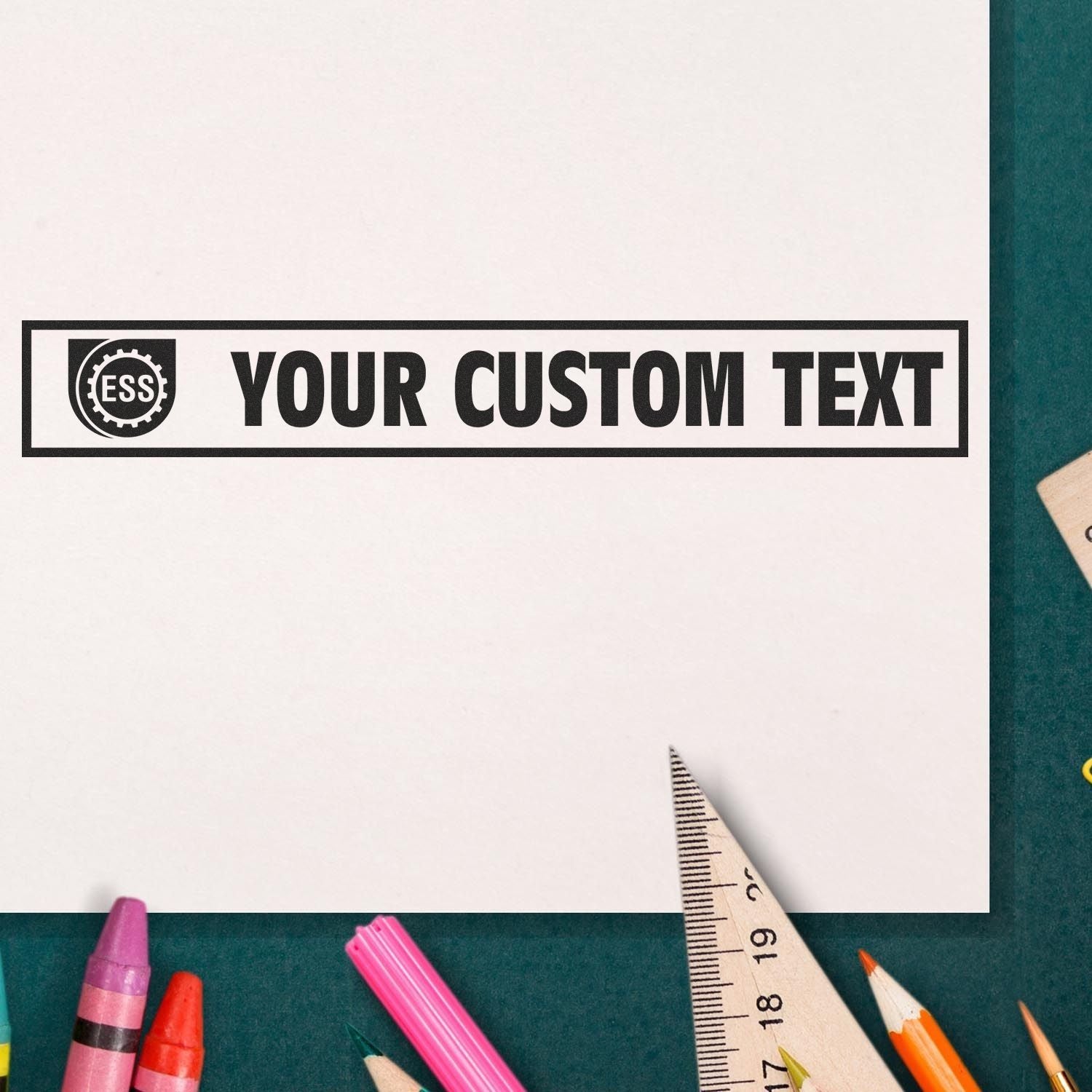 Custom Rubber Stamp Size 1-1/2 x 4 stamping YOUR CUSTOM TEXT on white paper, surrounded by colored pencils and a ruler.