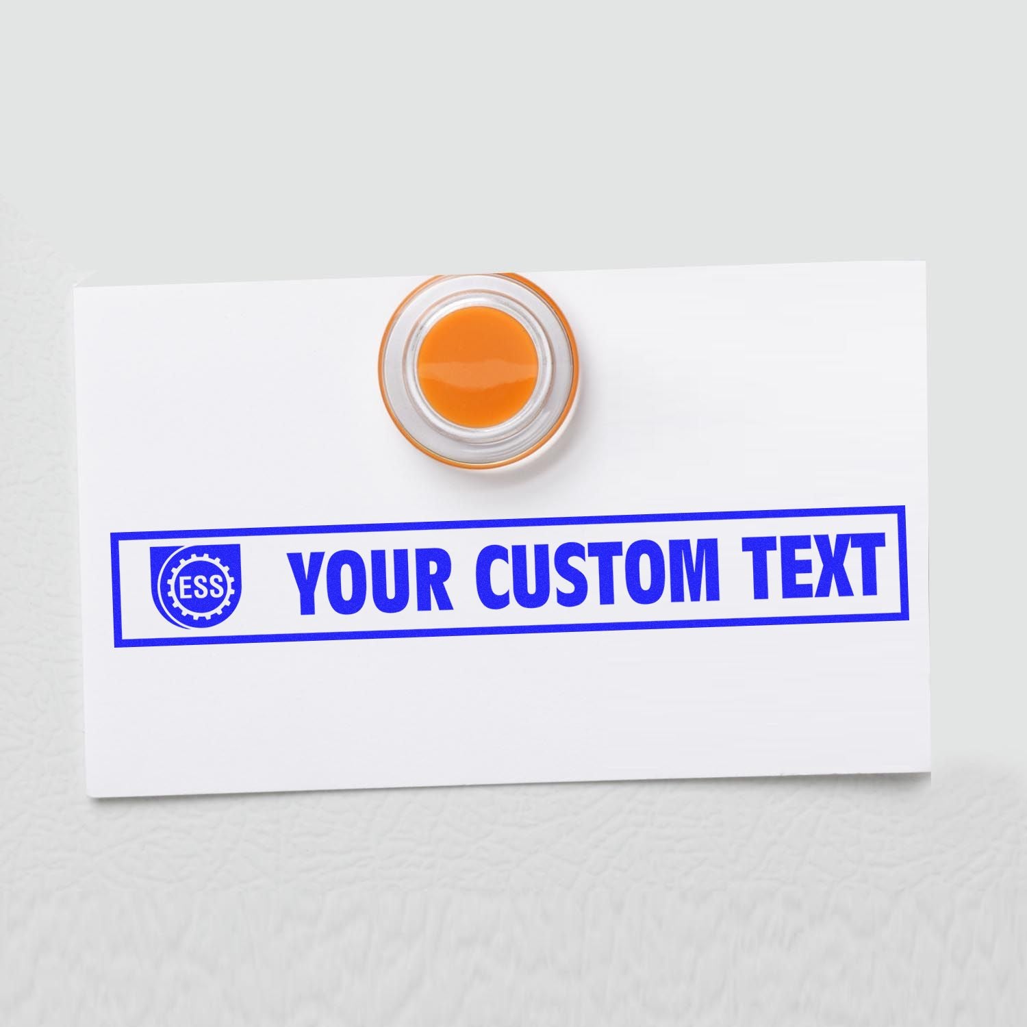 Custom Rubber Stamp Size 2 x 8 with YOUR CUSTOM TEXT in blue ink on a white card, featuring an orange circular handle.