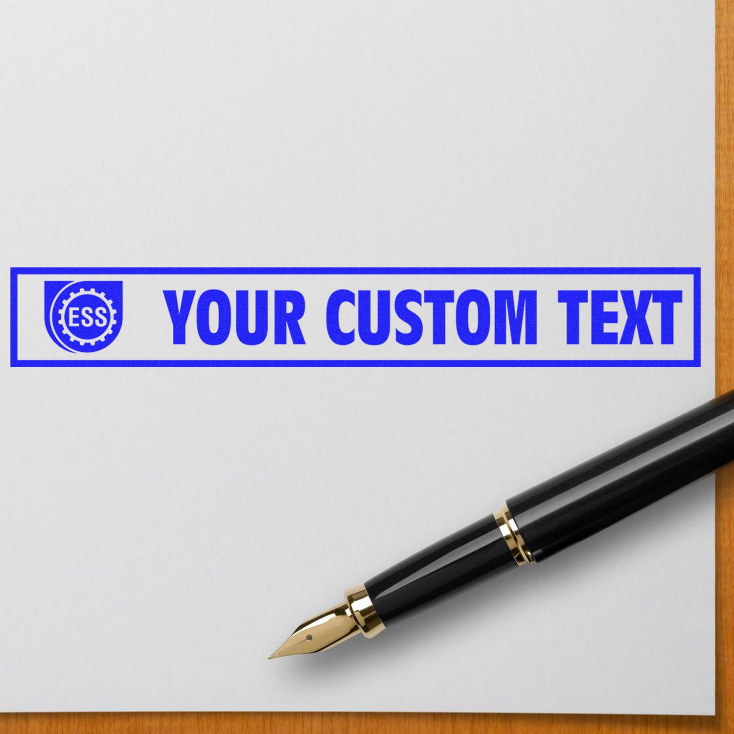 Custom Rubber Stamp Size 1-1/2 x 10 stamping YOUR CUSTOM TEXT in blue ink on white paper, with a black fountain pen nearby.