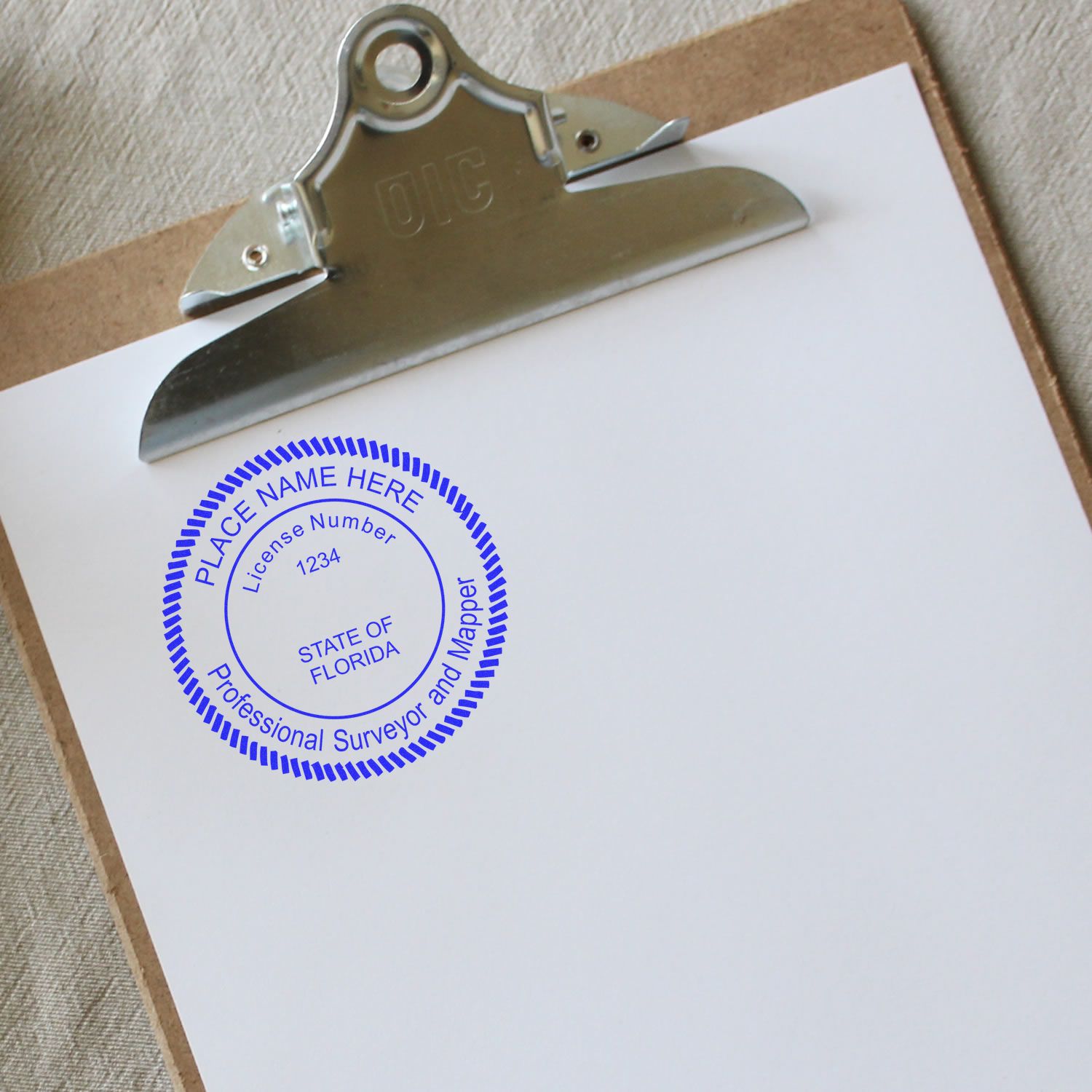 Premium MaxLight Pre-Inked Florida Surveyors Stamp on a clipboard with a blank sheet of paper, displaying a blue circular stamp impression.