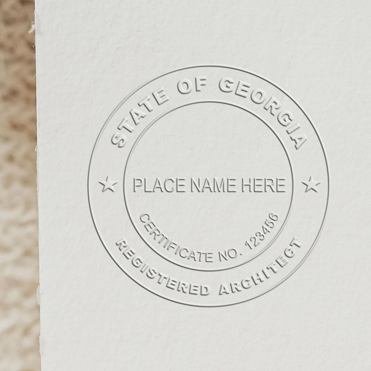 An in use photo of the Hybrid Georgia Architect Seal showing a sample imprint on a cardstock