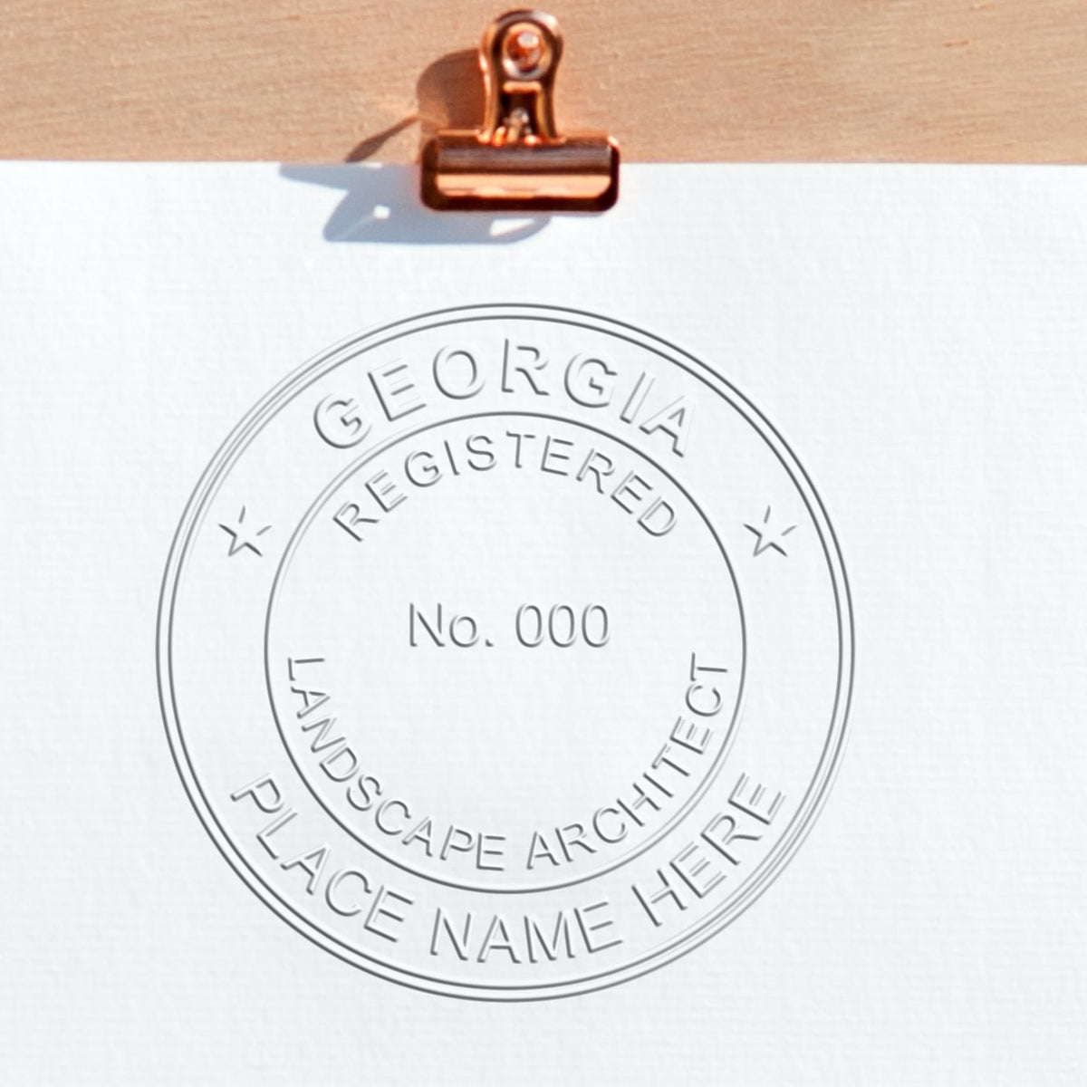 An in use photo of the Hybrid Georgia Landscape Architect Seal showing a sample imprint on a cardstock