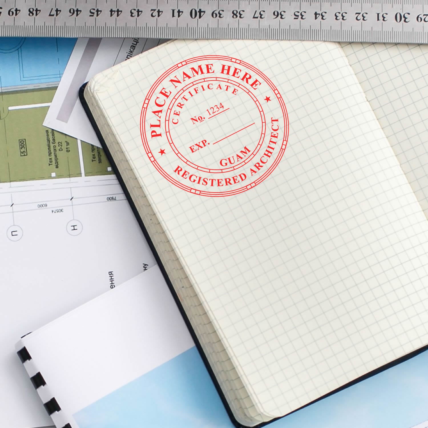 Digital Guam Architect Stamp, Electronic Seal for Guam Architect, stamped on a grid notebook with architectural plans and a ruler nearby.