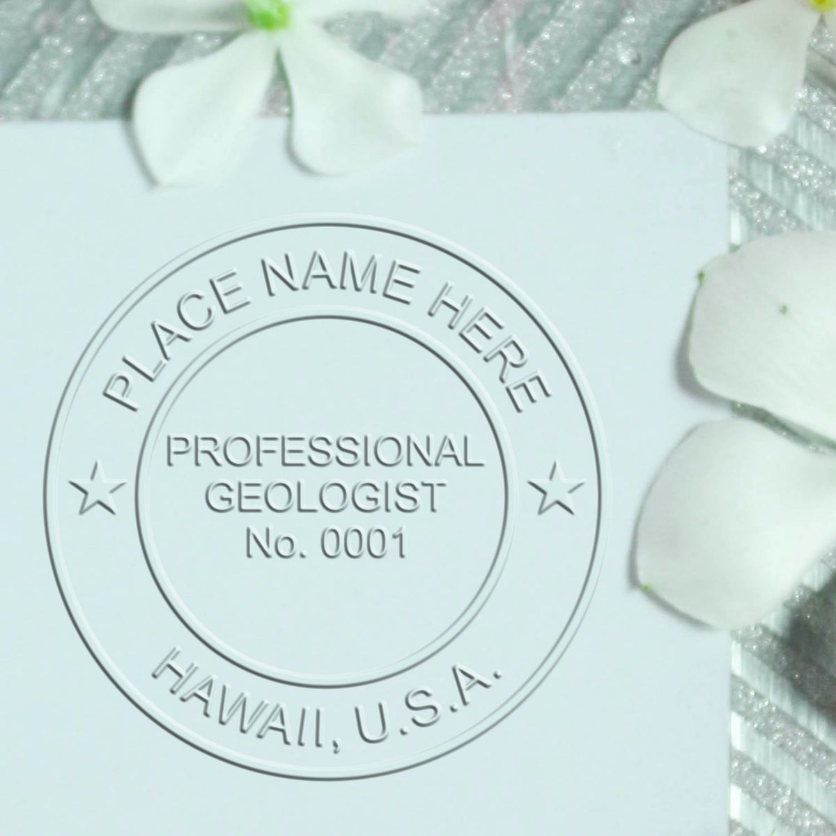 A lifestyle photo showing a stamped image of the Handheld Hawaii Professional Geologist Embosser on a piece of paper