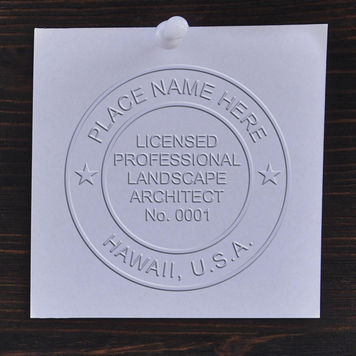 An in use photo of the Hybrid Hawaii Landscape Architect Seal showing a sample imprint on a cardstock