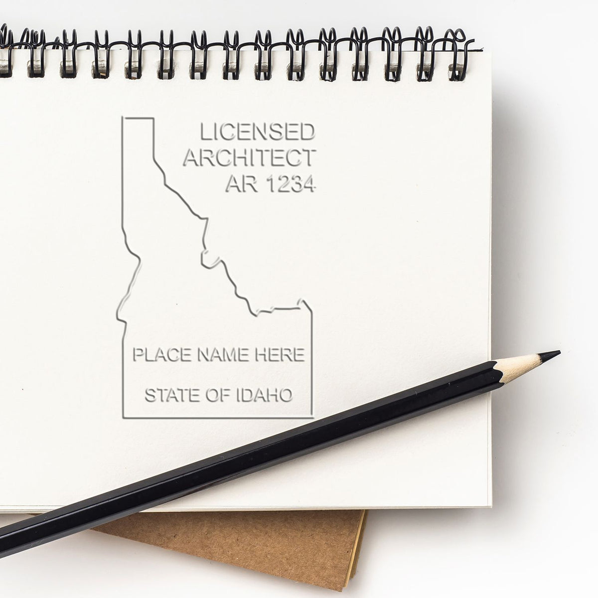 A lifestyle photo showing a stamped image of the Extended Long Reach Idaho Architect Seal Embosser on a piece of paper