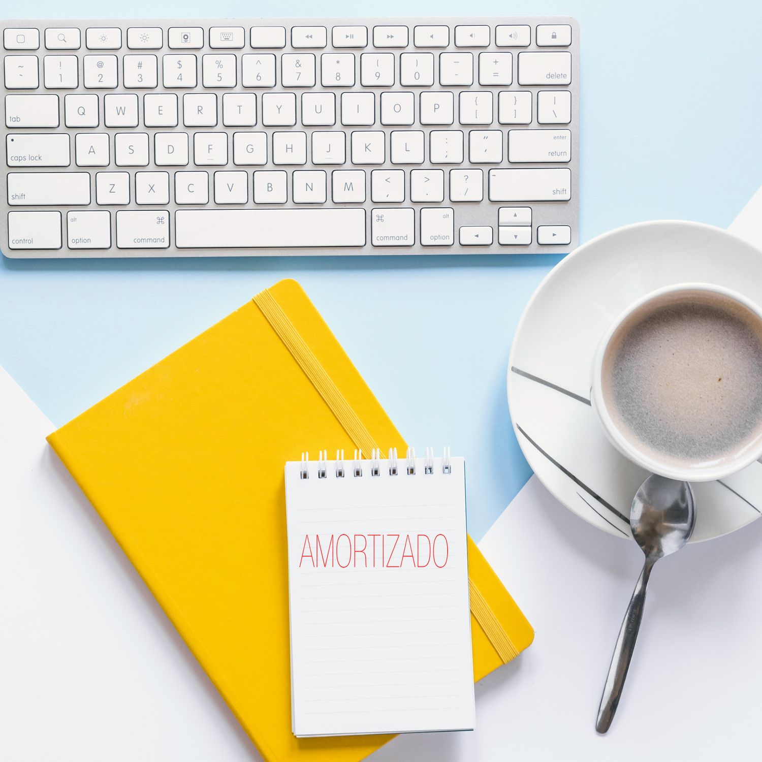 Amortizado rubber stamp on a notepad, next to a yellow notebook, keyboard, and a cup of coffee on a light blue and white background.