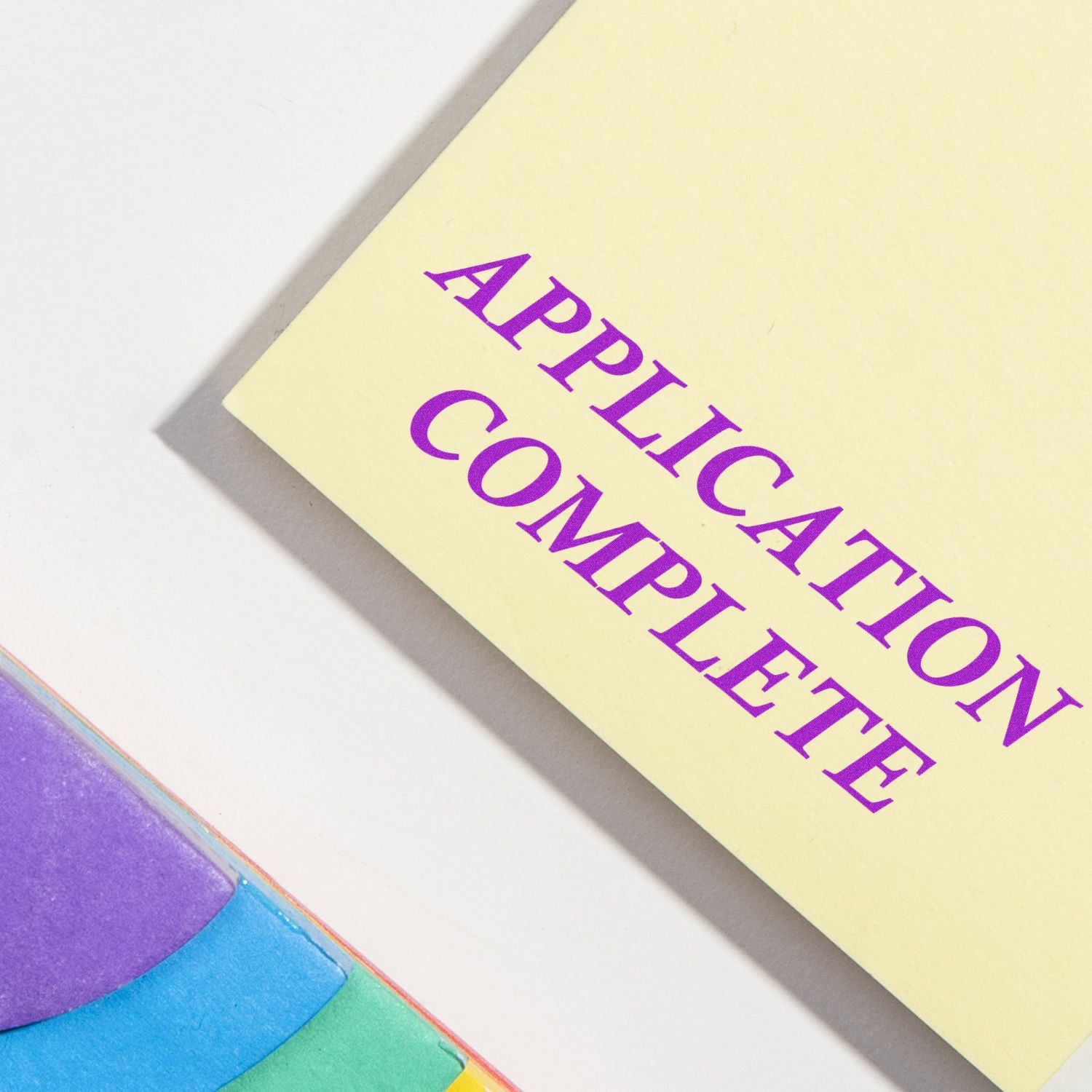 Document stamped with 'APPLICATION COMPLETE' using the Large Self Inking Application Complete Stamp, next to colorful sticky notes.