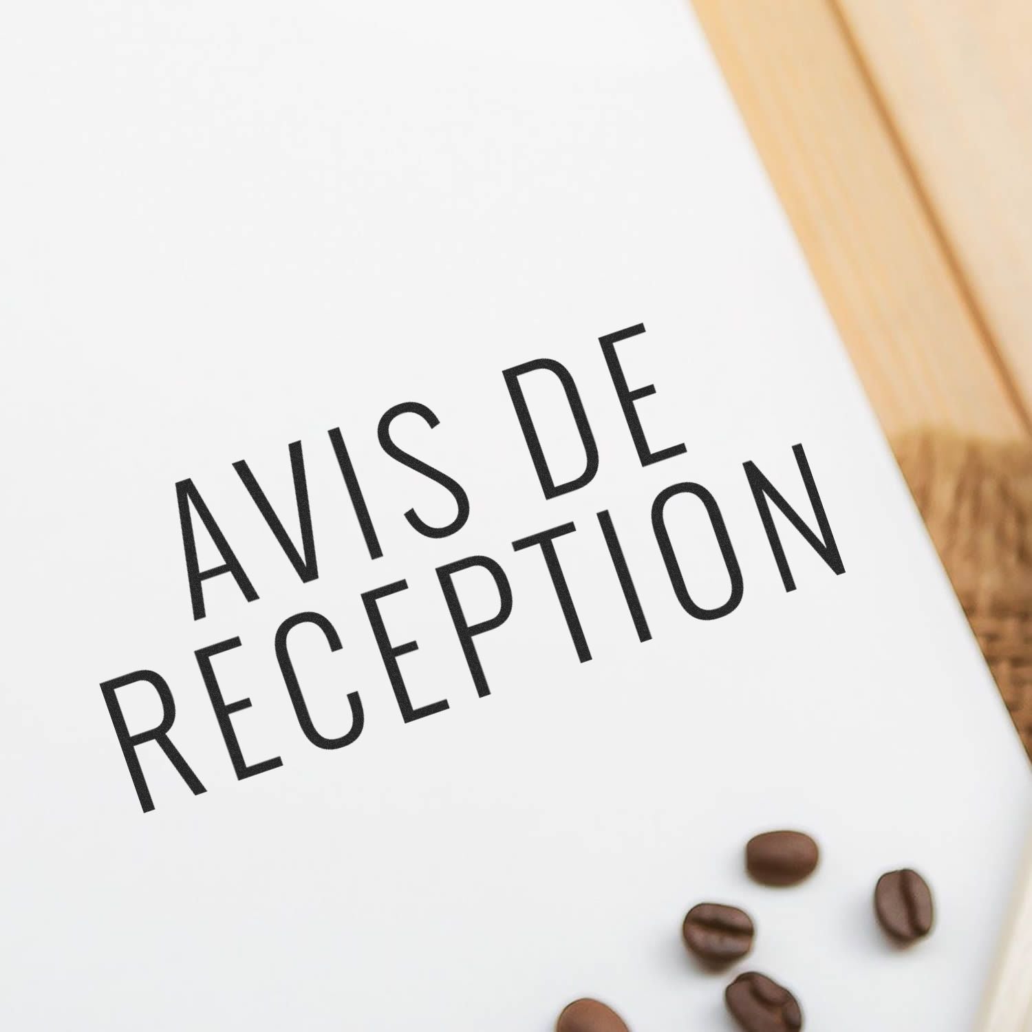 Avis De Reception rubber stamp impression on white paper with scattered coffee beans and a wooden surface in the background.