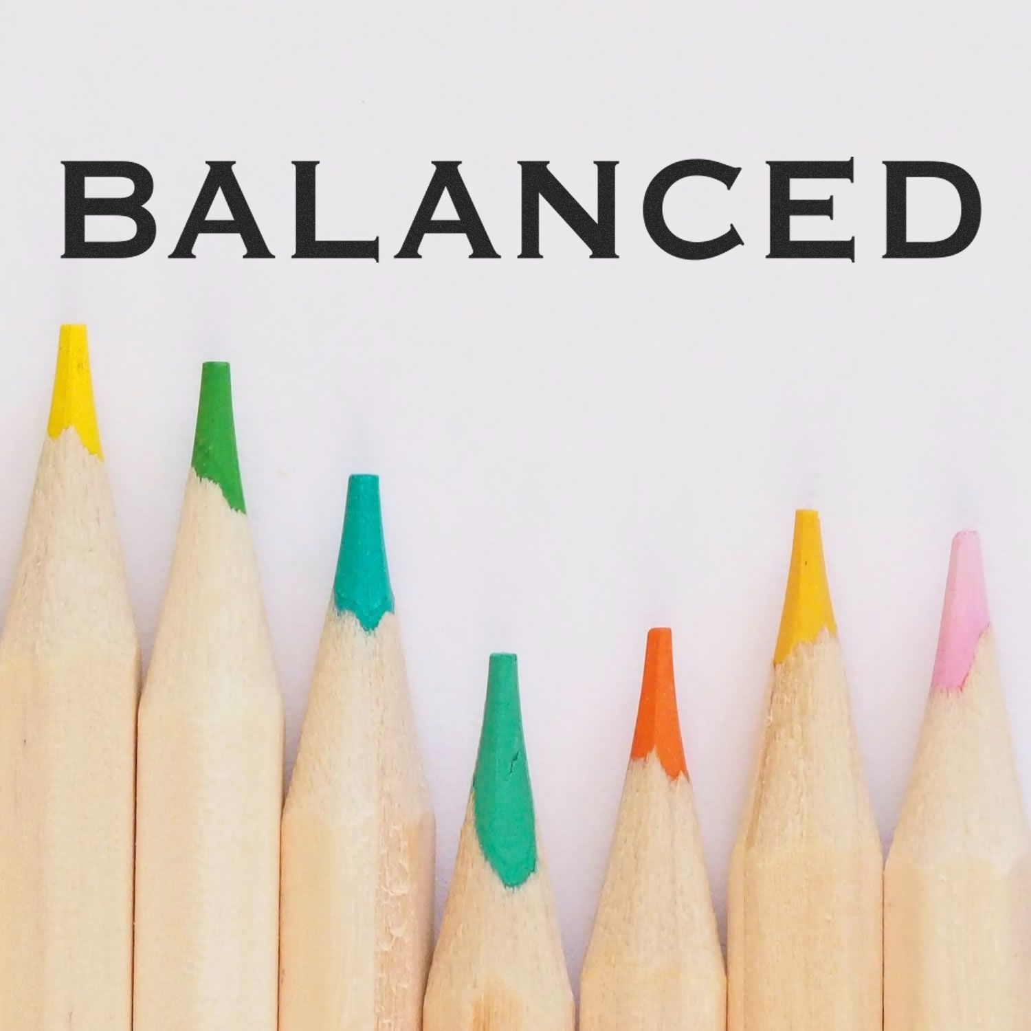 Colored pencils arranged in a row below the word BALANCED stamped using the Self Inking Balanced Stamp.