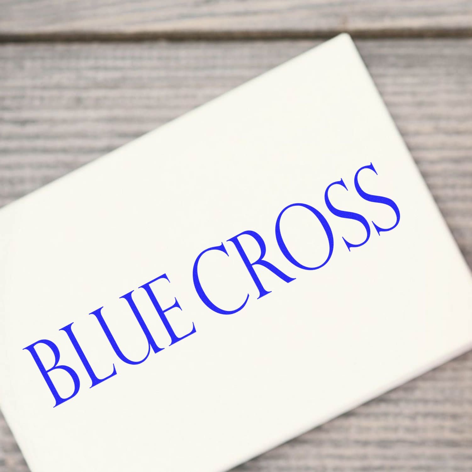 Slim Pre-Inked Blue Cross Stamp in use, displaying a clear blue BLUE CROSS imprint on a white surface.