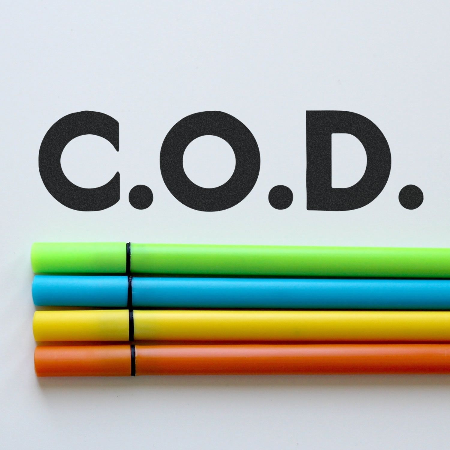 Bold COD rubber stamp impression with colorful markers placed below the text on a white background.