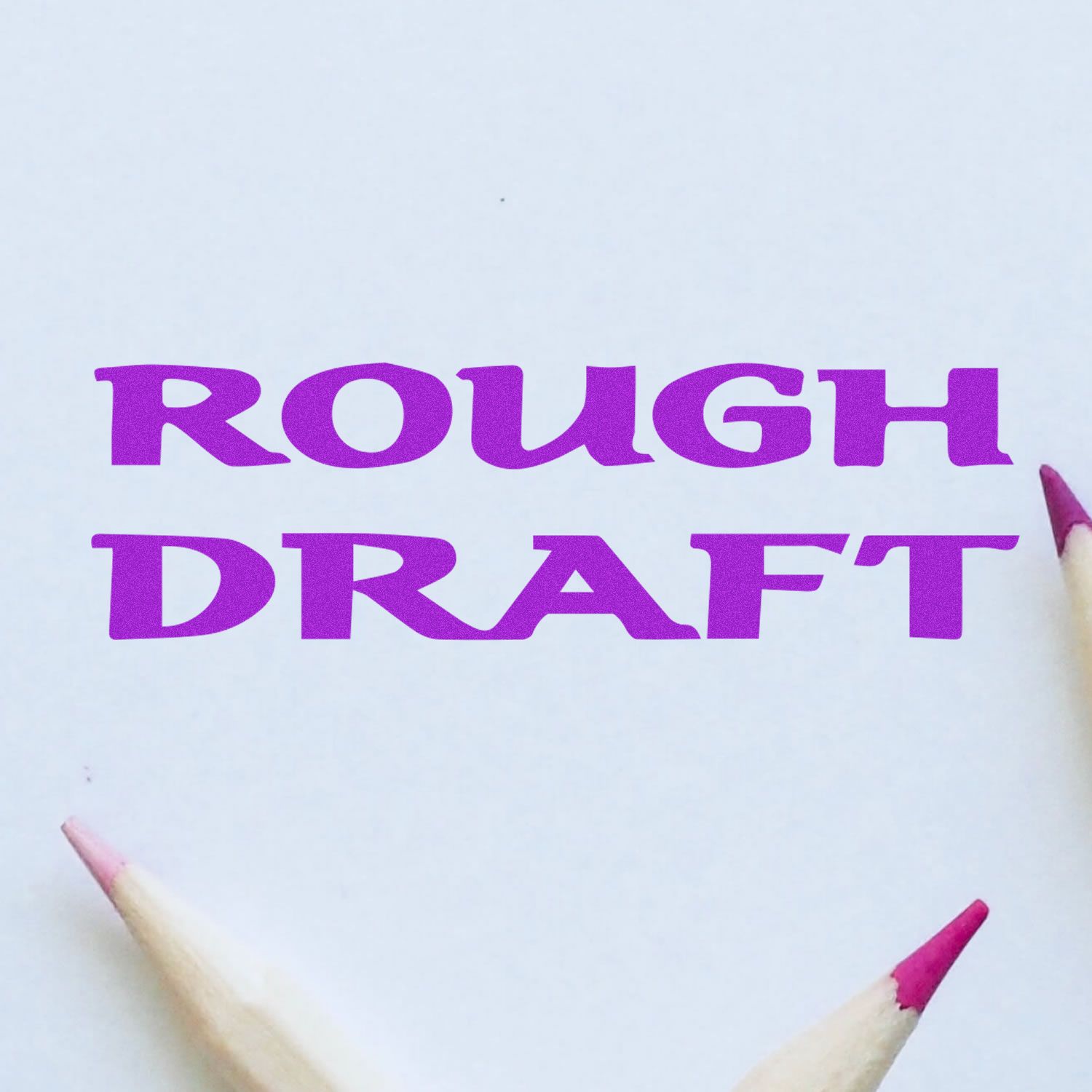 Bold Rough Draft rubber stamp impression in purple ink on white paper, surrounded by three pencils with pink erasers.