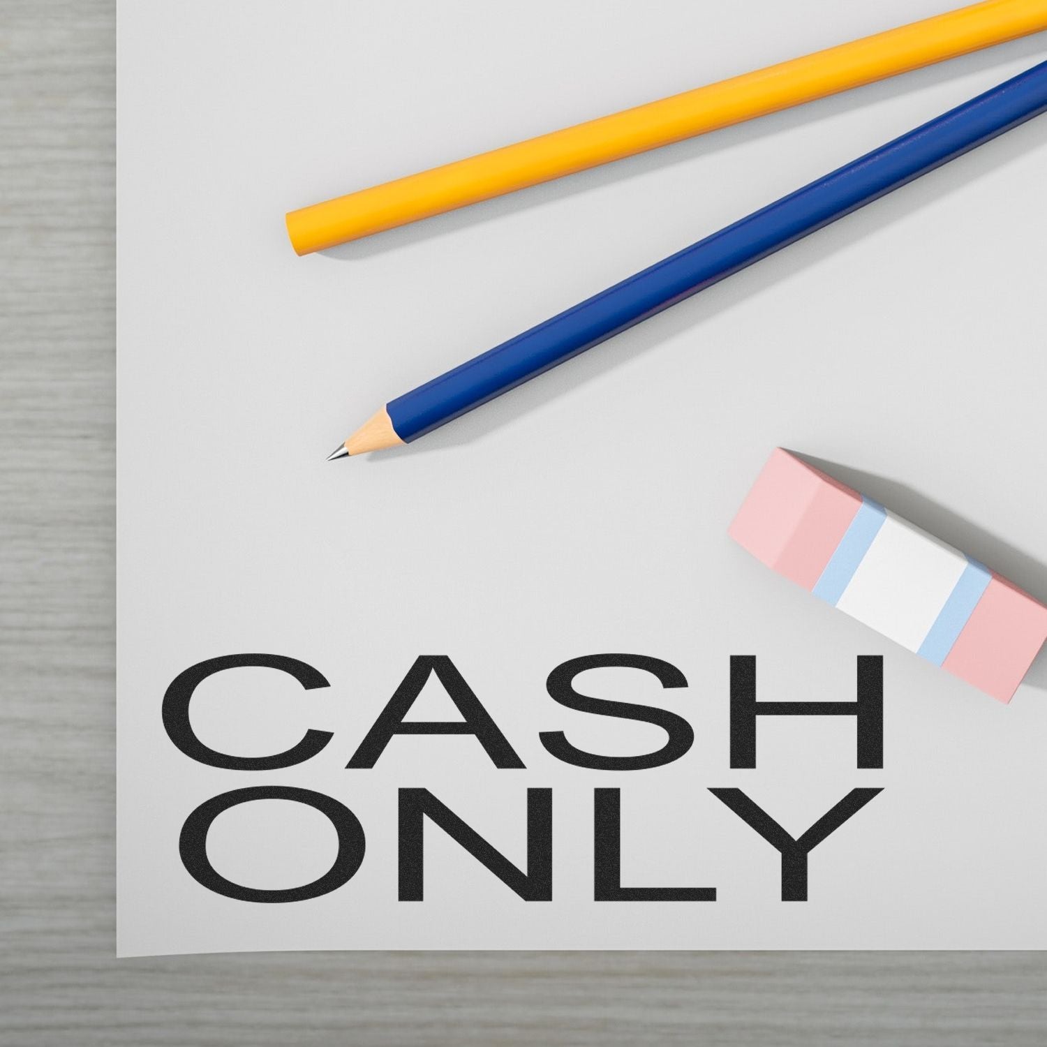 Cash Only Rubber Stamp impression on paper, with a pencil, pen, and eraser nearby on a light-colored surface.