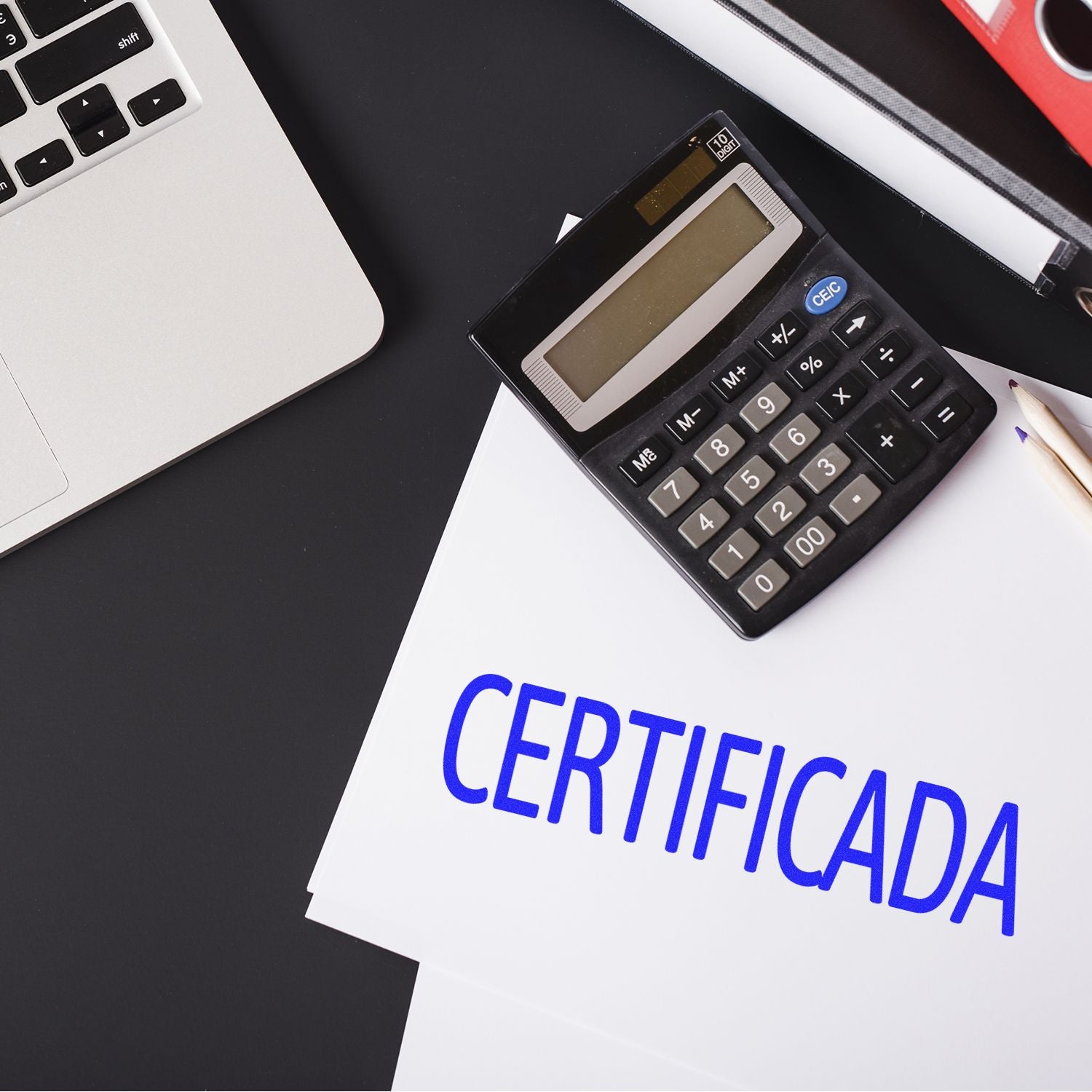 Large Pre-Inked Certificada Stamp used on a document next to a calculator, pencil, and laptop on a black desk.