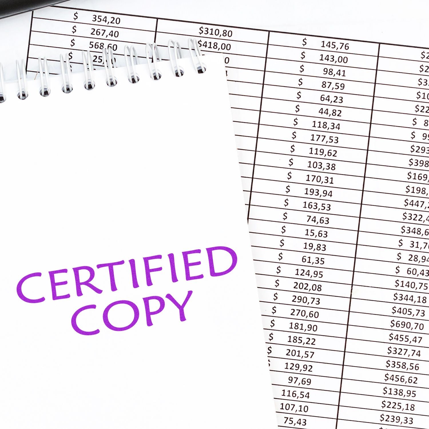 Large Self Inking Certified Copy Stamp in purple ink on a notepad, placed over financial documents with numbers and calculations.