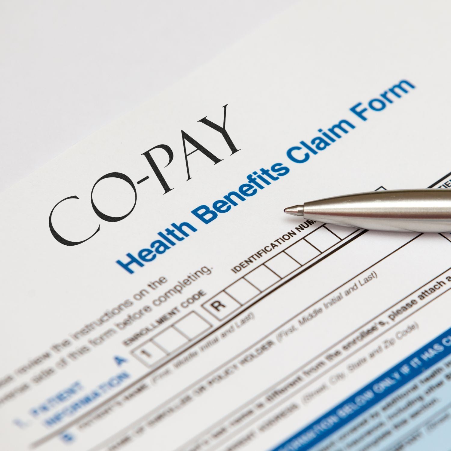 Person using a Slim Pre-Inked Co-Pay Stamp on a Health Benefits Claim Form, with a pen nearby.