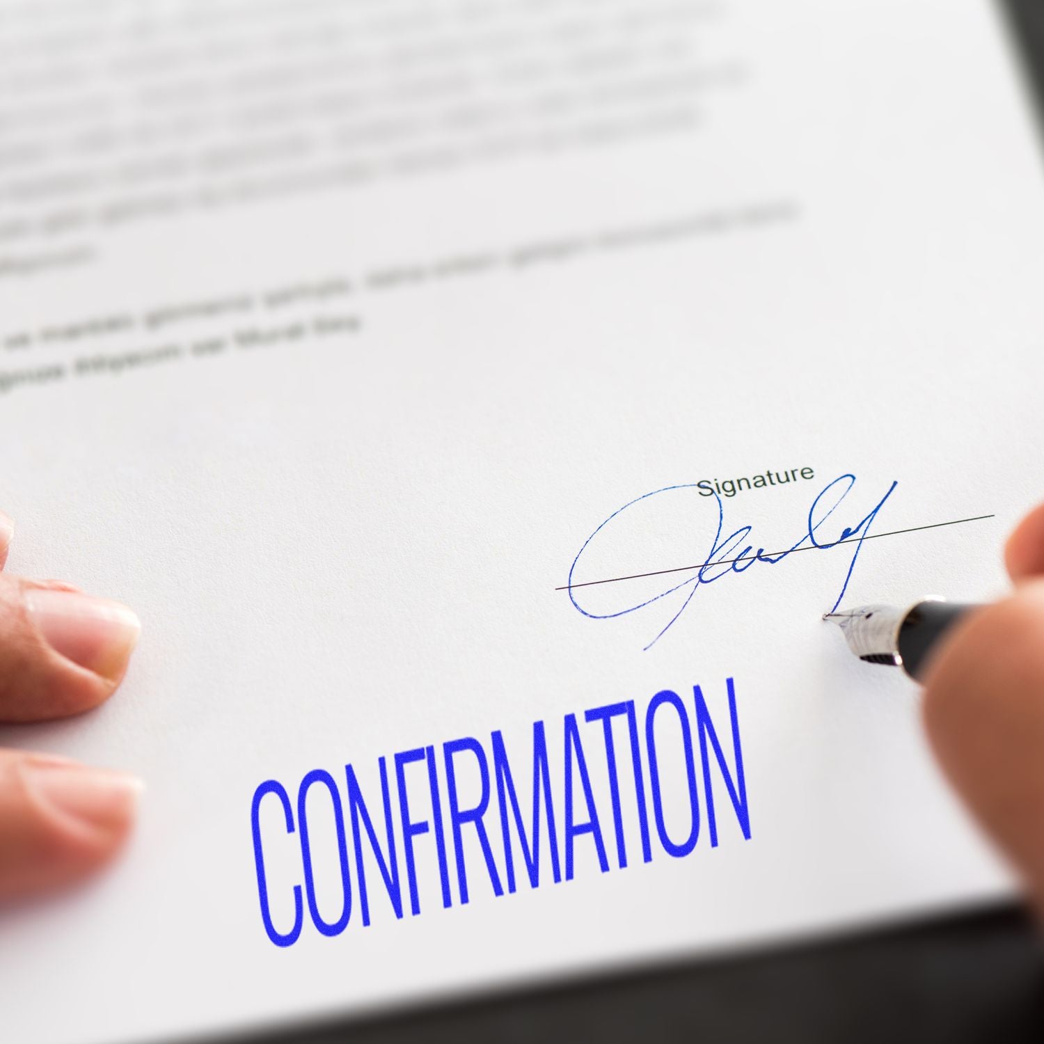 Person signing a document with a pen, featuring a blue Confirmation Rubber Stamp mark prominently displayed on the paper.