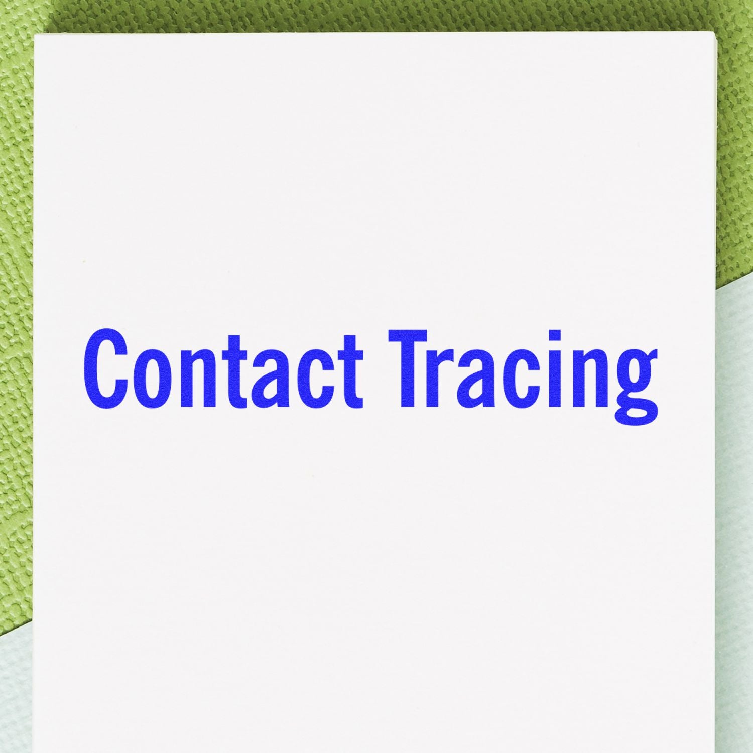 Contact Tracing Rubber Stamp imprint in blue ink on white paper, placed on a textured green and white background.