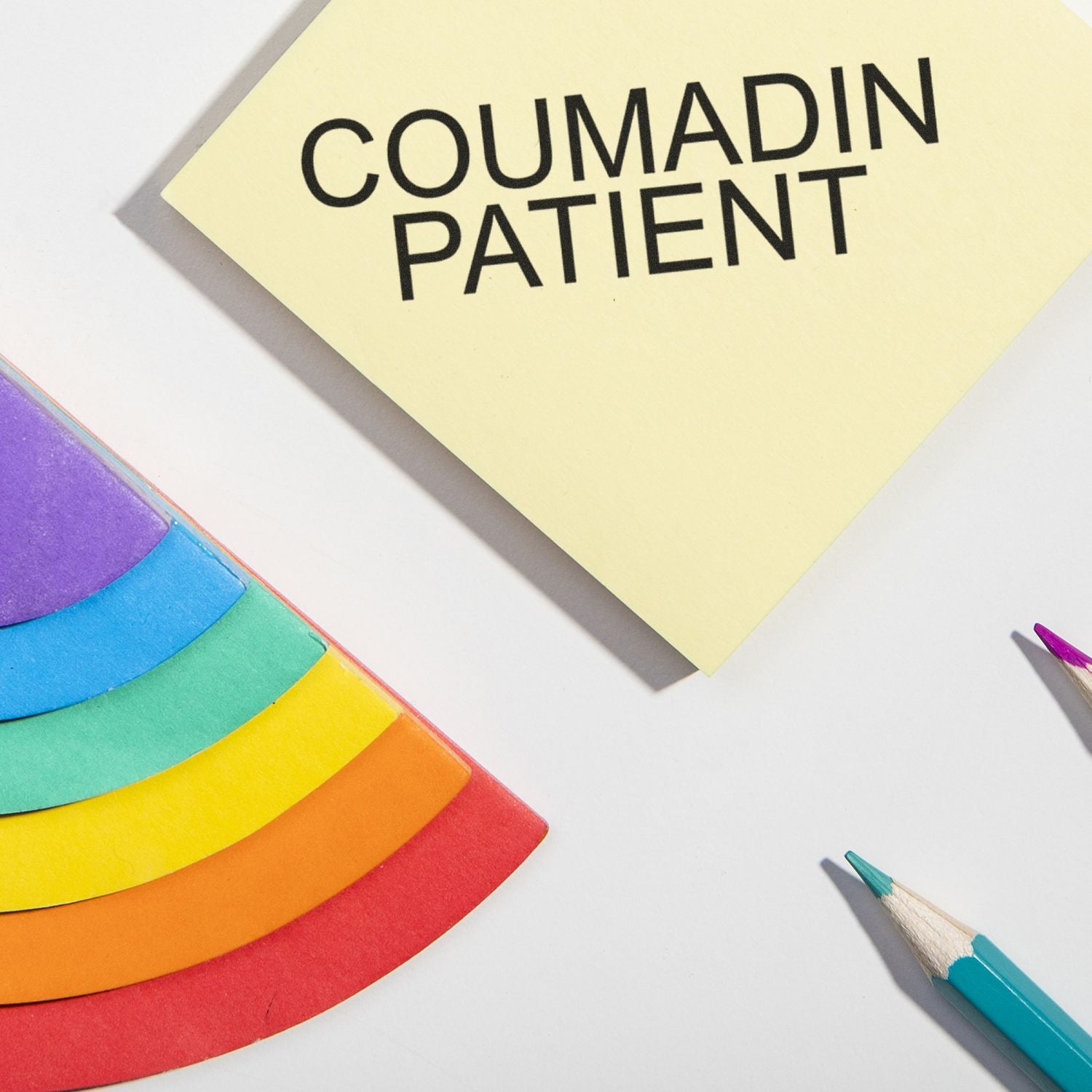 Coumadin Patient Rubber Stamp in use, stamping COUMADIN PATIENT on a yellow paper, surrounded by colorful folders and pencils.