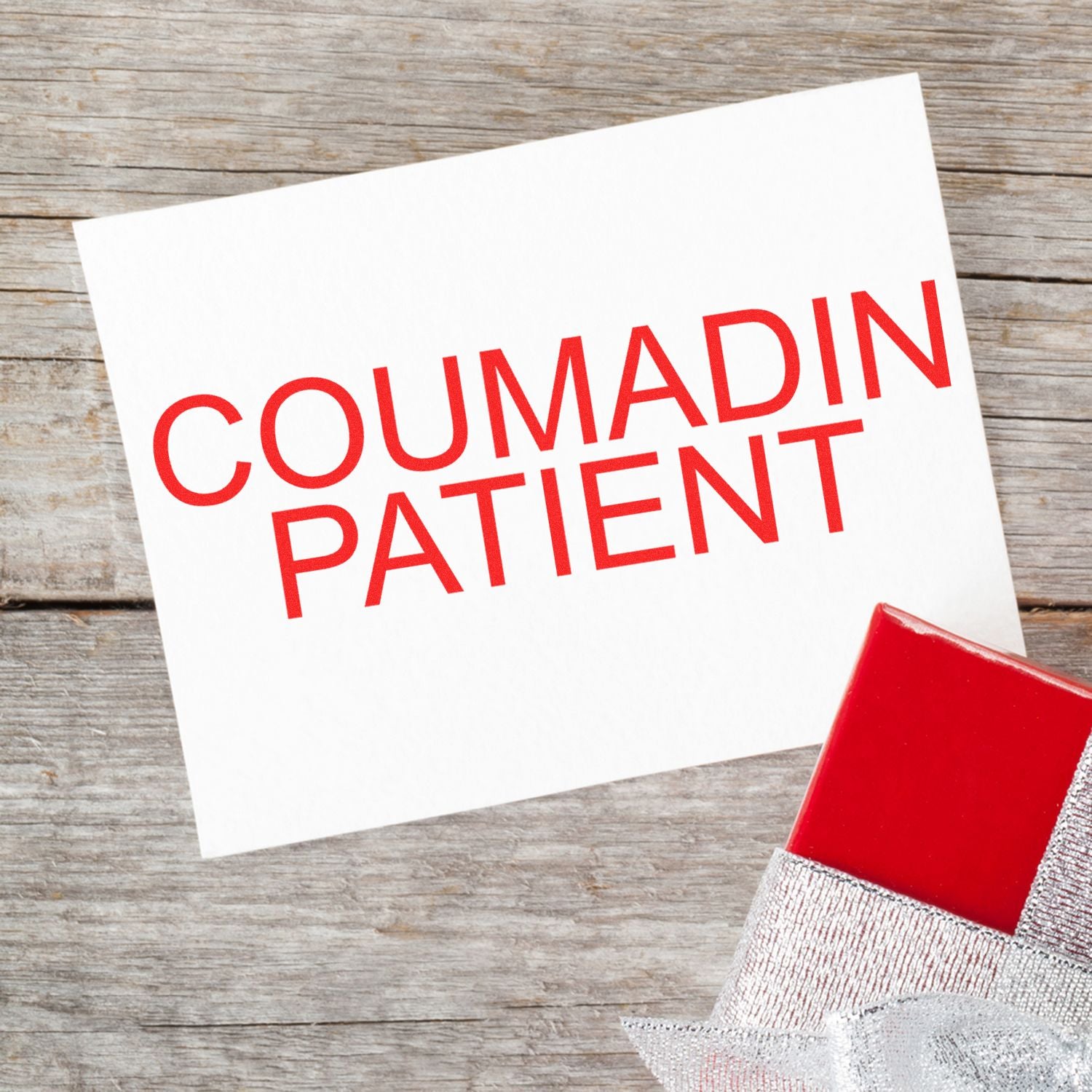 A card stamped with COUMADIN PATIENT in red ink using the Large Coumadin Patient Rubber Stamp, placed on a wooden surface.