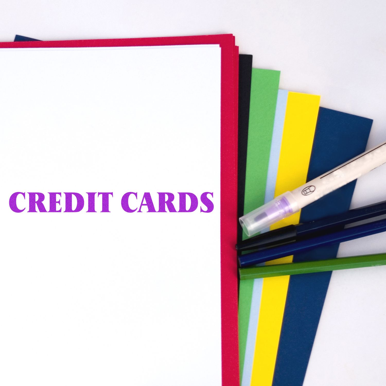 Large Self Inking Credit Cards Stamp in use on white paper with colored sheets and pens in the background.