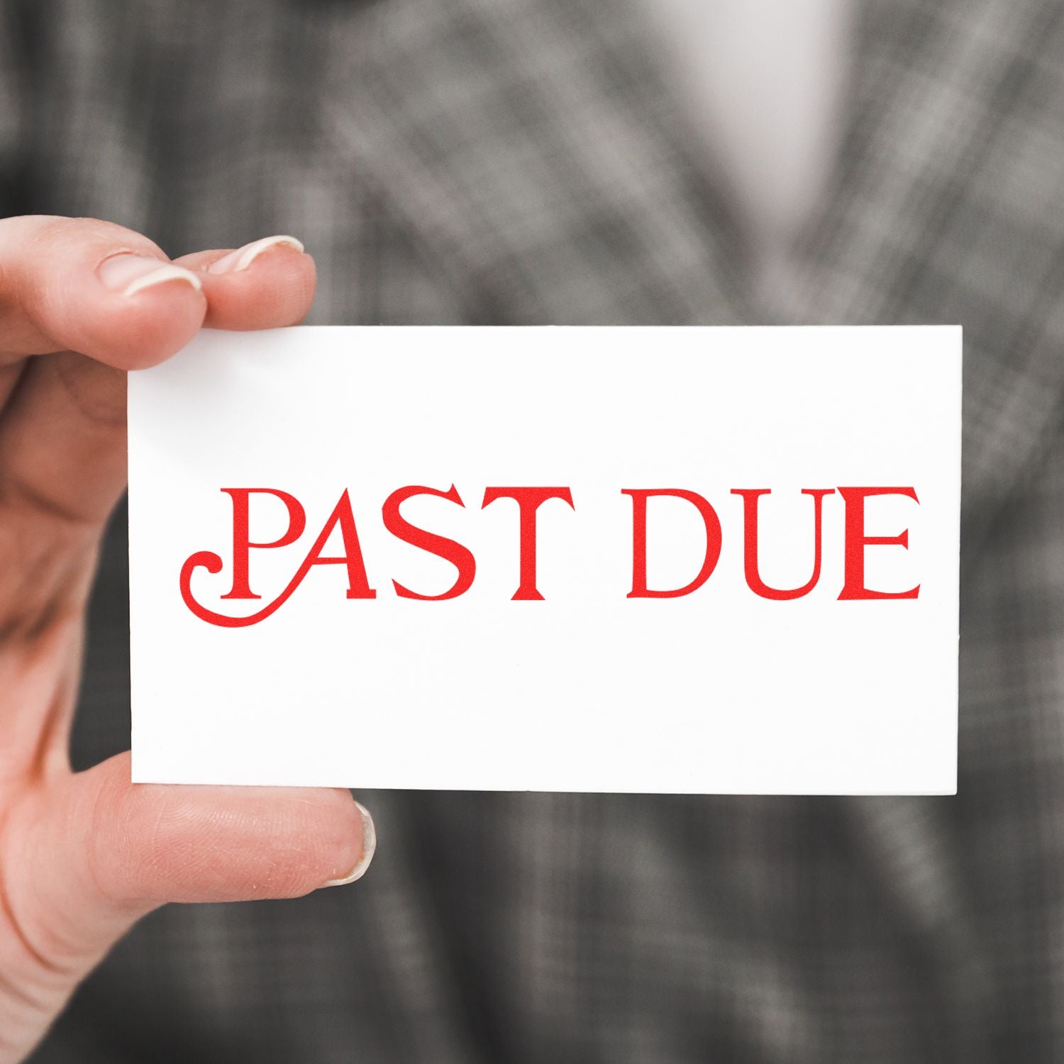 Hand holding a white card stamped with PAST DUE in red ink using the Large Pre-Inked Curley Past Due Stamp, with a blurred background.