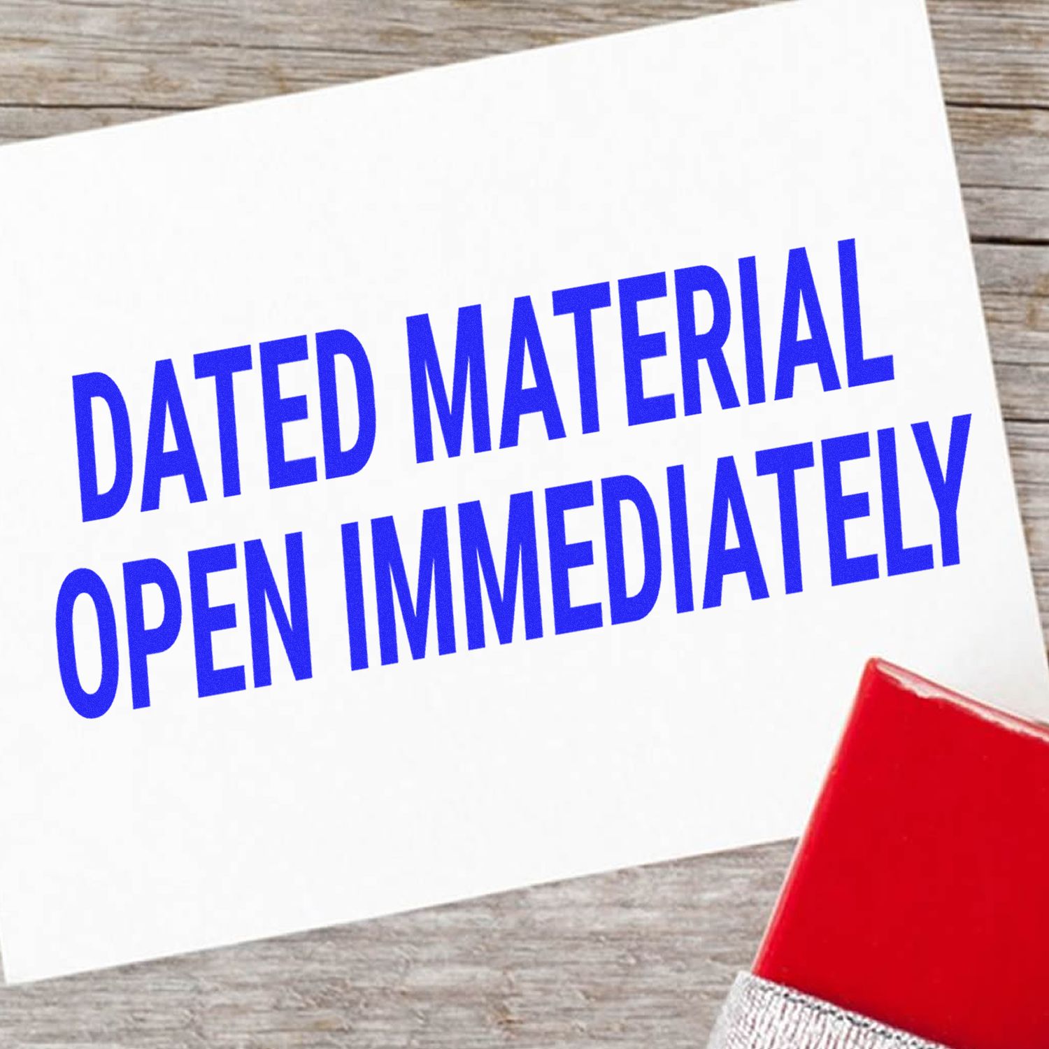 A red Dated Material Open Immediately Rubber Stamp on a white paper with the stamped message DATED MATERIAL OPEN IMMEDIATELY in blue.