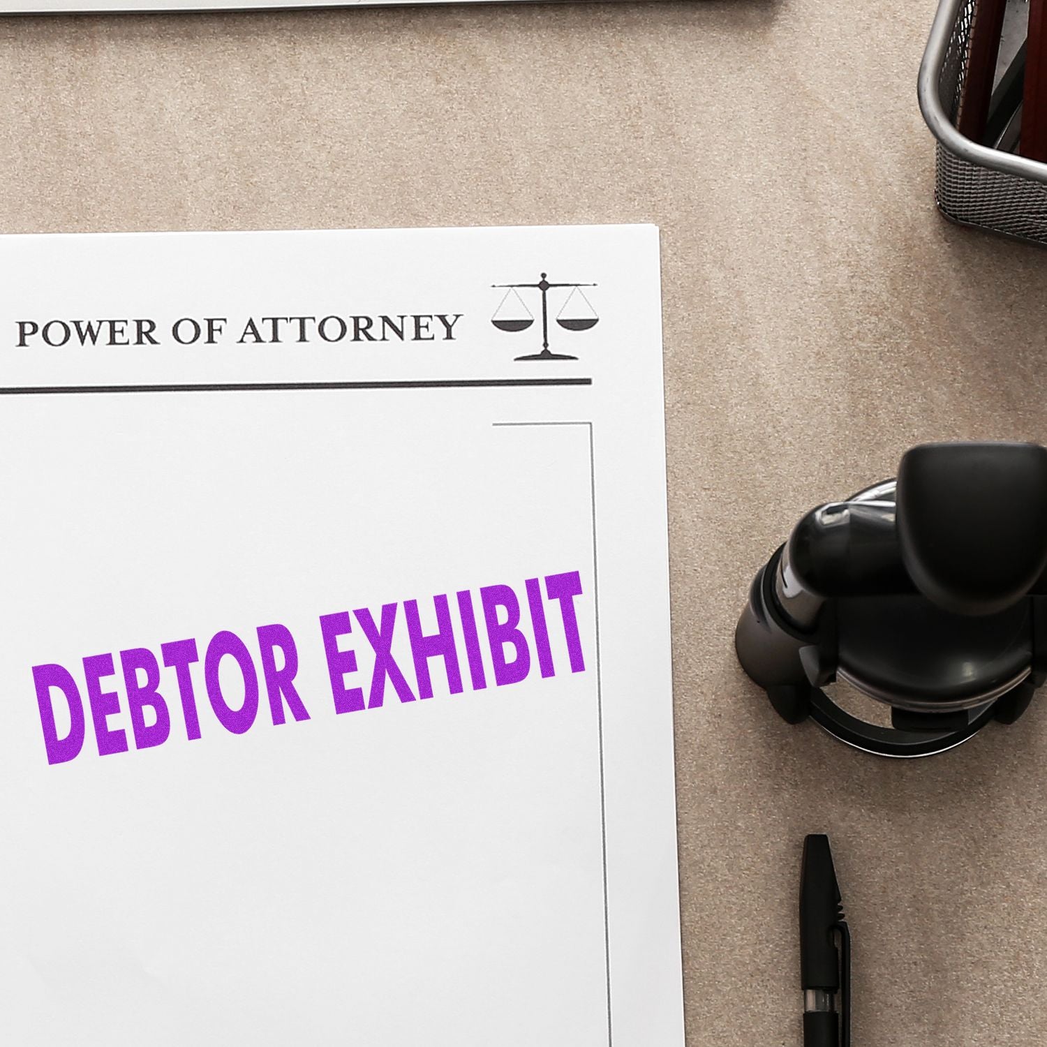 Self Inking Debtor Exhibit Stamp in use on a Power of Attorney document, with the stamp and pen placed on a beige desk.