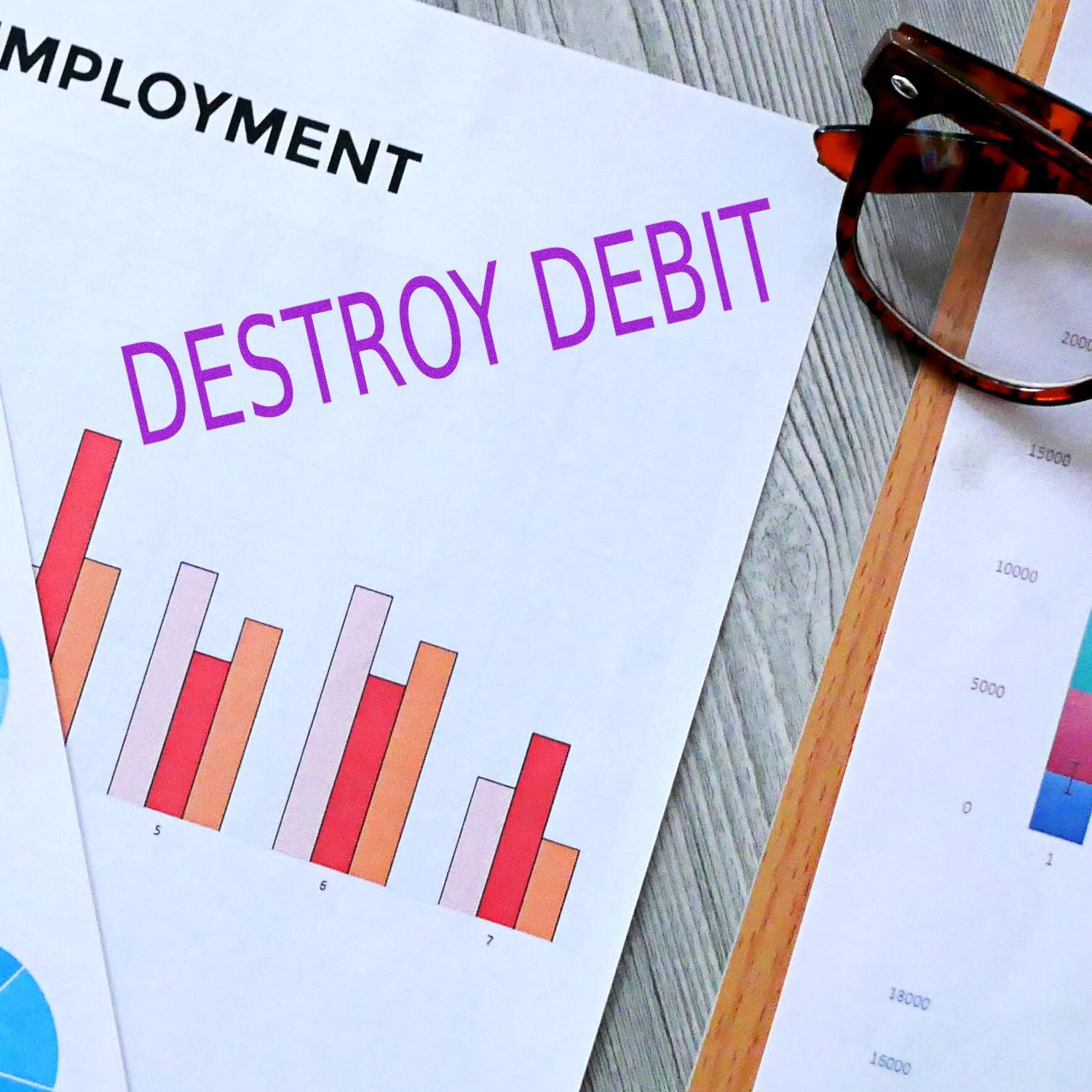 A document stamped with DESTROY DEBIT using the Large Self Inking Destroy Debit Stamp, placed on a desk with charts and glasses nearby.