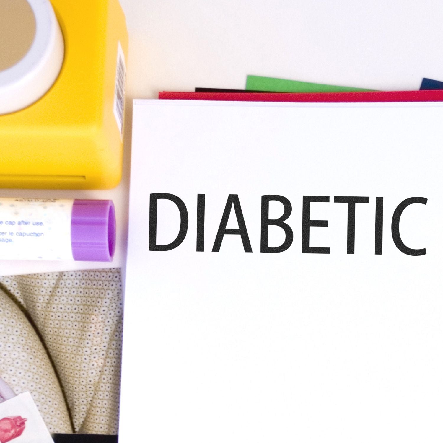 Large Diabetic Rubber Stamp marking DIABETIC on a white sheet, with a yellow stamp pad and other office supplies in the background.