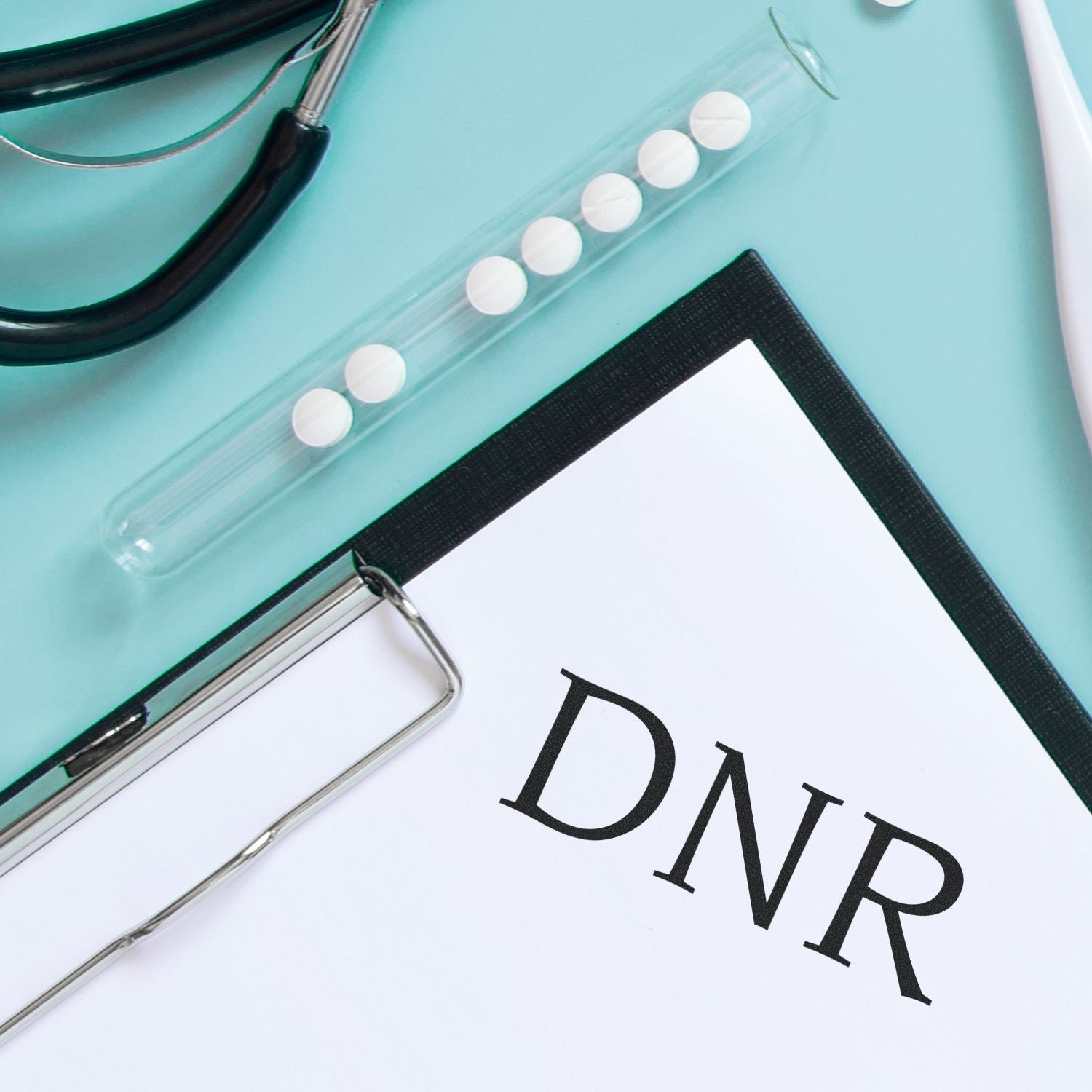 Slim Pre-Inked DNR Stamp next to a medical clipboard with DNR document, stethoscope, and test tube with pills on a blue background.