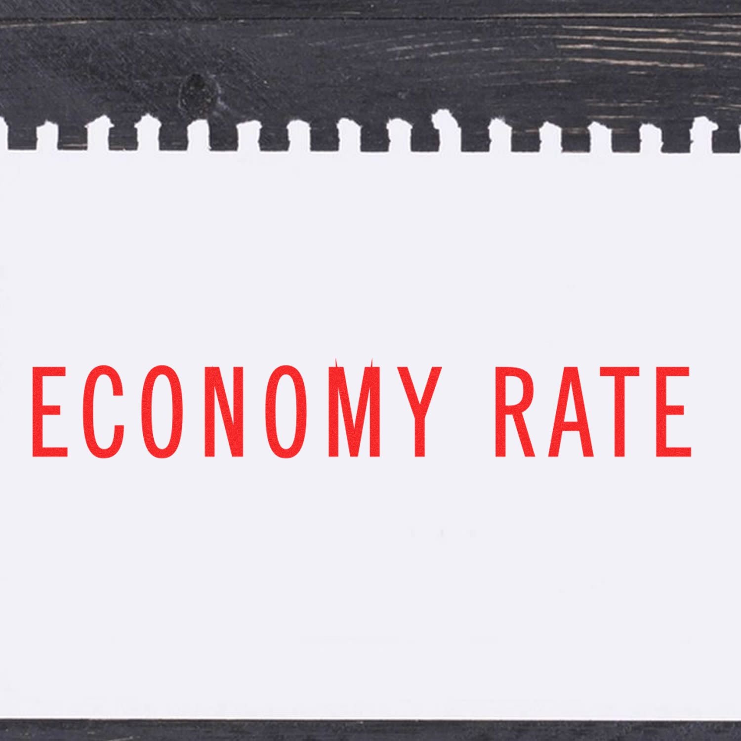 Self Inking Economy Rate Stamp imprinting ECONOMY RATE in red ink on a white notepad with a black wooden background.