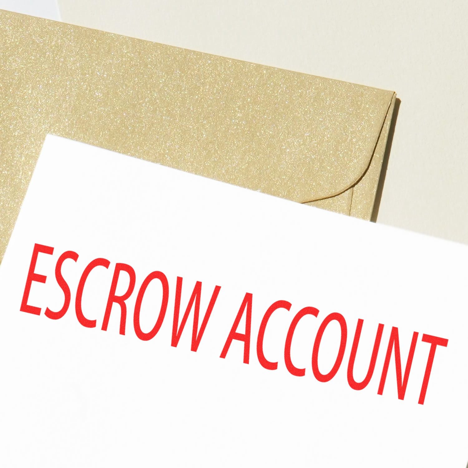 Close-up of a document stamped with 'ESCROW ACCOUNT' in red ink using the Escrow Account Rubber Stamp, placed next to a gold envelope.