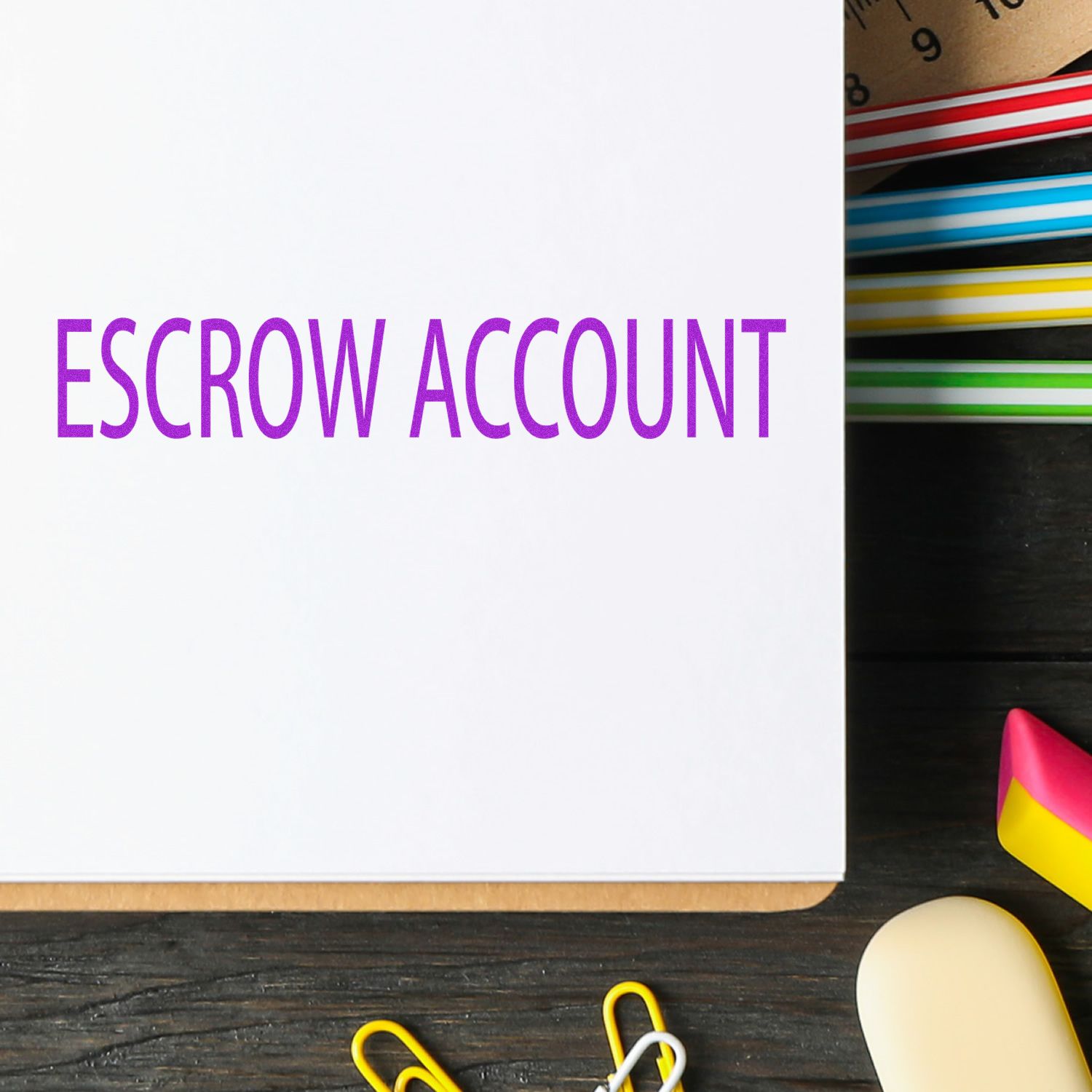 Escrow Account Rubber Stamp in purple ink on white paper, surrounded by colorful office supplies on a dark wooden desk.