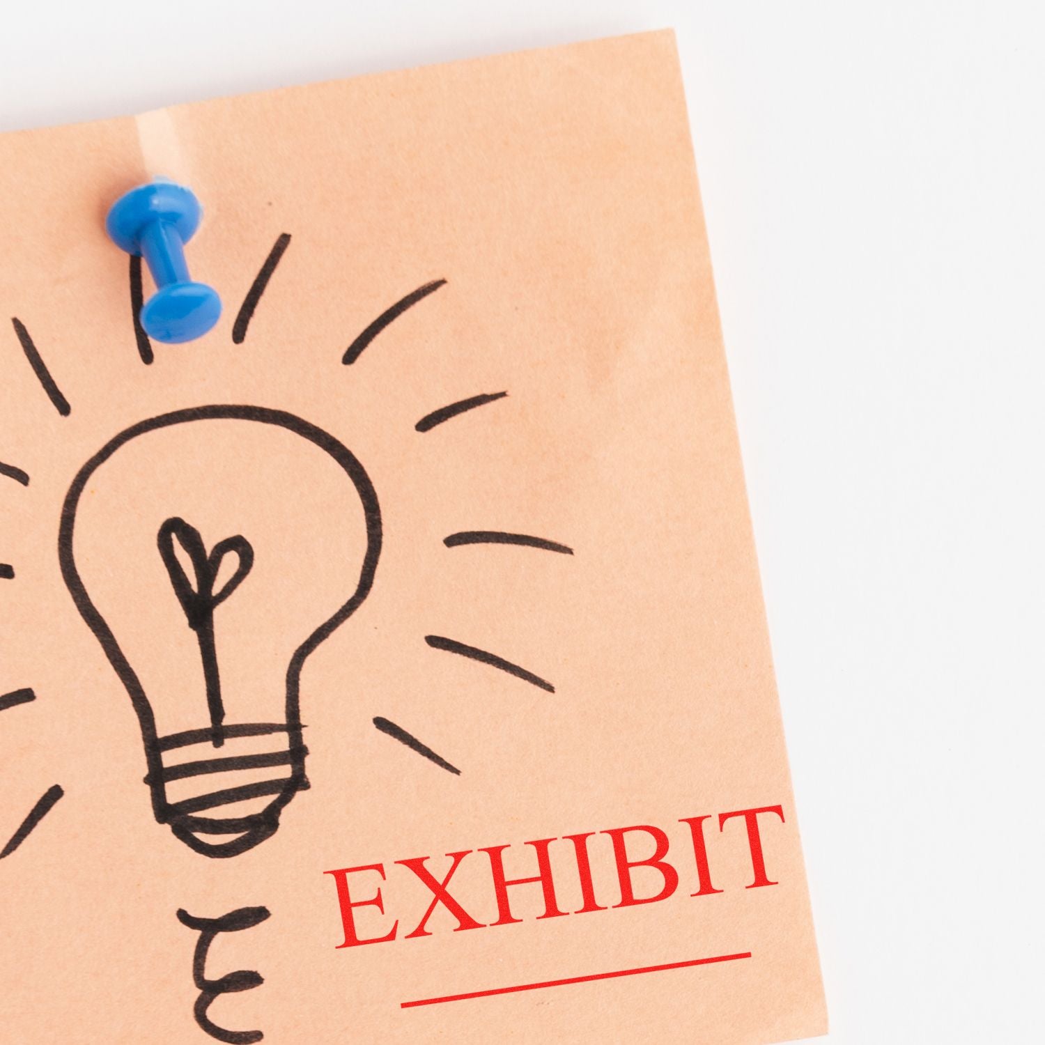 A brown paper with a lightbulb drawing pinned to a board, stamped with EXHIBIT in red using a Self Inking Exhibit Stamp.