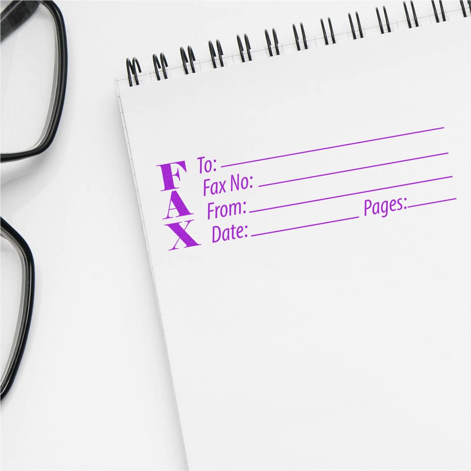 Fax Rubber Stamp in use on a white notepad with glasses nearby. The stamp has fields for To, Fax No, From, Date, and Pages in purple ink.