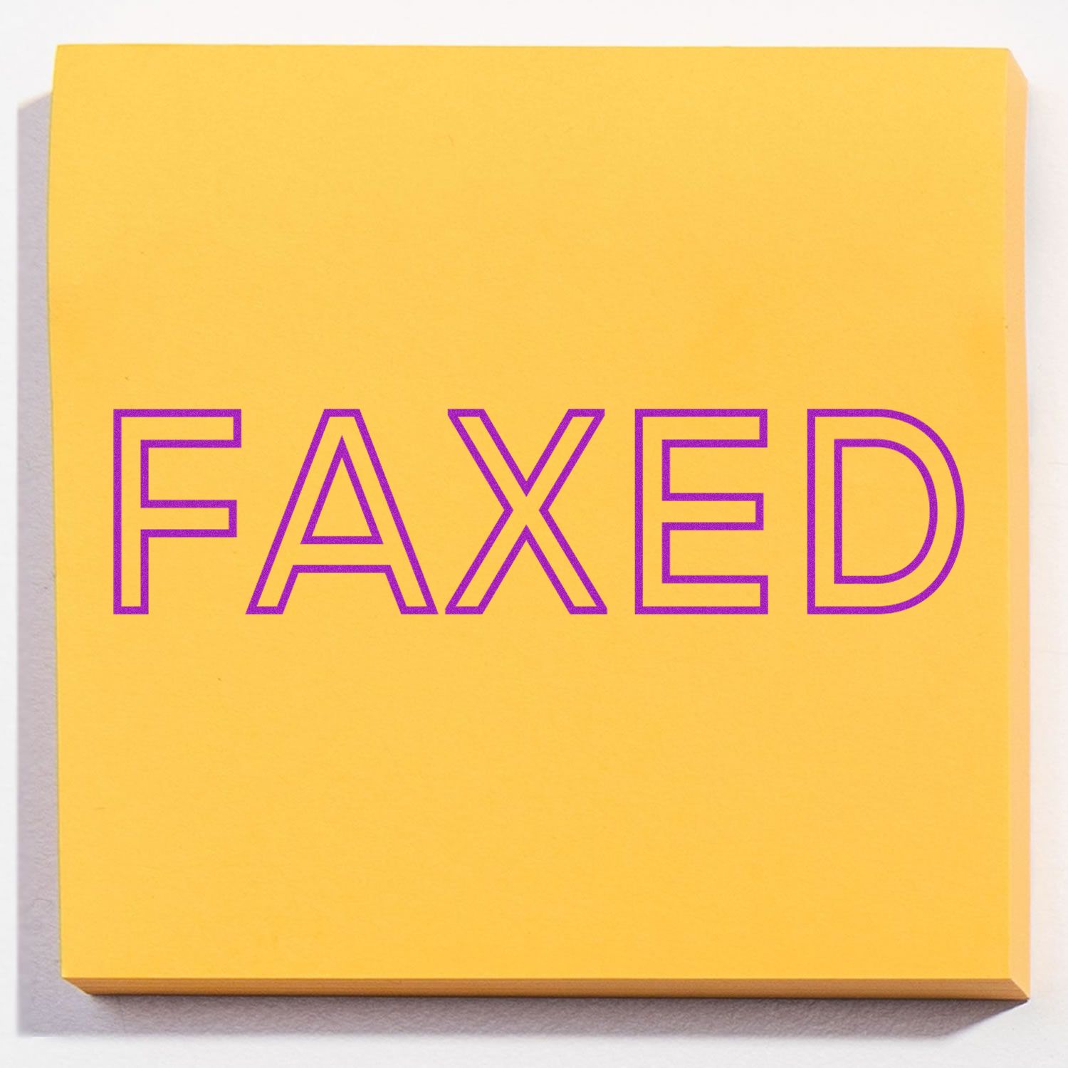 Slim Pre-Inked Faxed Stamp on a yellow sticky note with the word FAXED in purple letters.