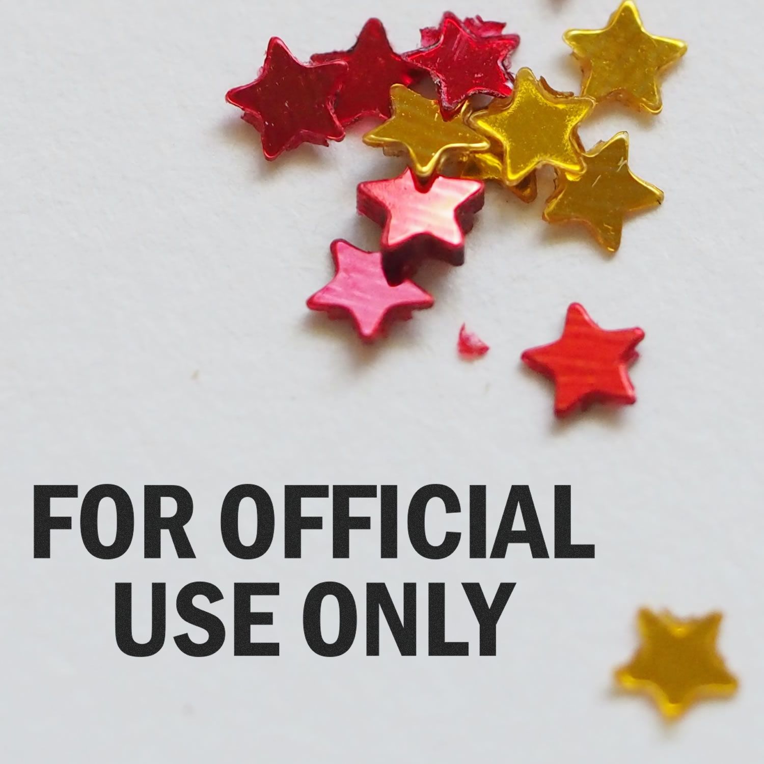 For Official Use Only Rubber Stamp text on white paper with red and gold star-shaped confetti scattered around.