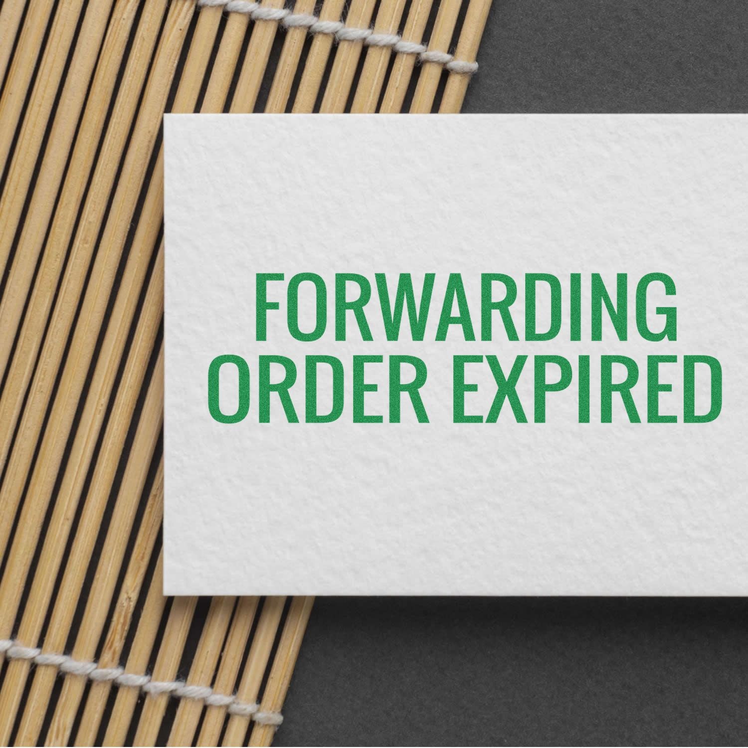 Forwarding Order Expiring Rubber Stamp used on white paper with green text 'FORWARDING ORDER EXPIRED' placed on a bamboo mat.