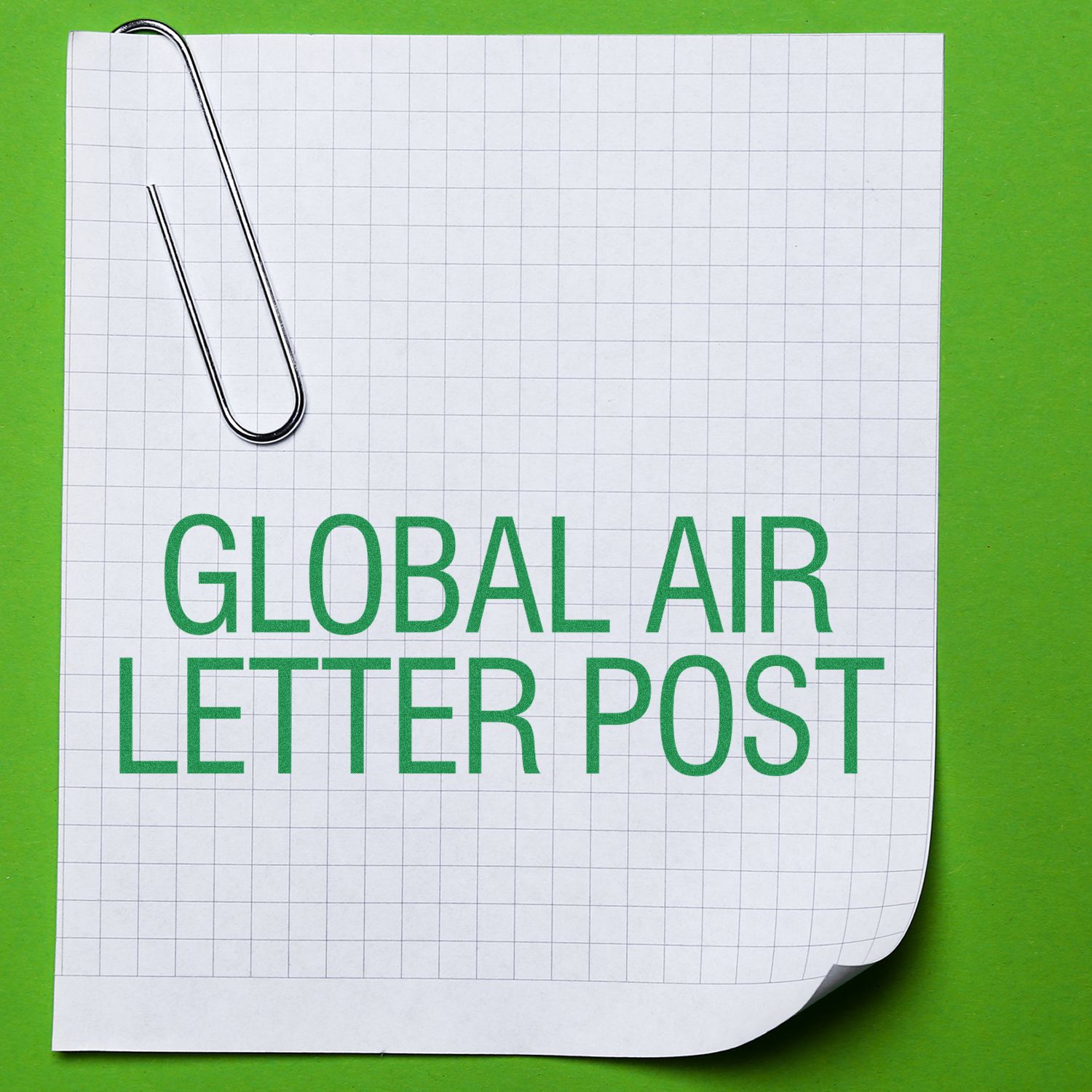 Slim Pre-Inked Global Air Letter Post Stamp on a grid paper with a paperclip, placed on a green background.