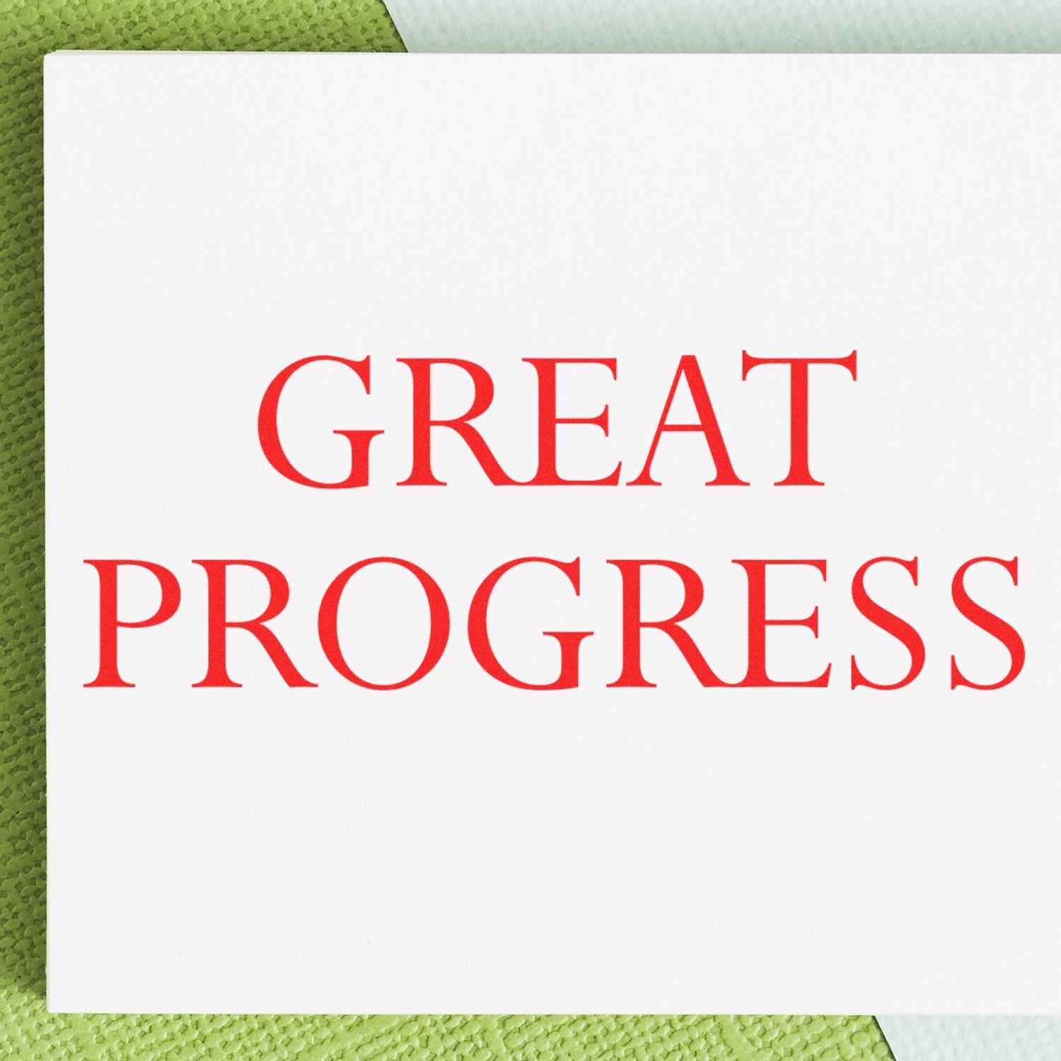 Great Progress Rubber Stamp in use, displaying bold red text 'GREAT PROGRESS' on white paper with a green textured background.